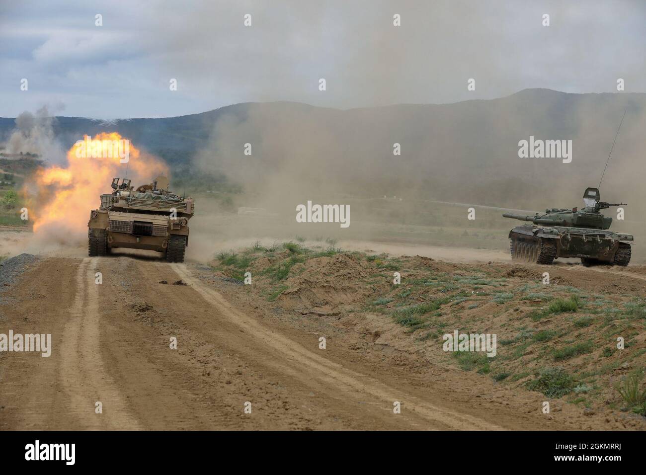 NOVO SELO TRAINING RANGE, Bulgarien – Ein Panzer der US-Armee M1A2 Abrams feuert bei einer Live-Feuer-Übung zur Unterstützung von Sabre Guardian im Novo Selo Training Range am 30. Mai 2021 zusammen mit einem Kampfpanzer der bulgarischen Streitkräfte T-72 auf sein Ziel. Sabre Guardian 21 ist eine verknüpfte Übung von DEFENDER-Europe 21. DEFENDER-Europe 21 ist eine groß angelegte Übung unter Führung der US-Armee, die darauf ausgelegt ist, Bereitschaft und Interoperabilität zwischen den USA, NATO-Verbündeten und Partnermilitärs aufzubauen. In diesem Jahr werden mehr als 28,000 multinationale Streitkräfte aus 26 Nationen nahezu simultan Operationen über mehr als 30 Tr durchführen Stockfoto
