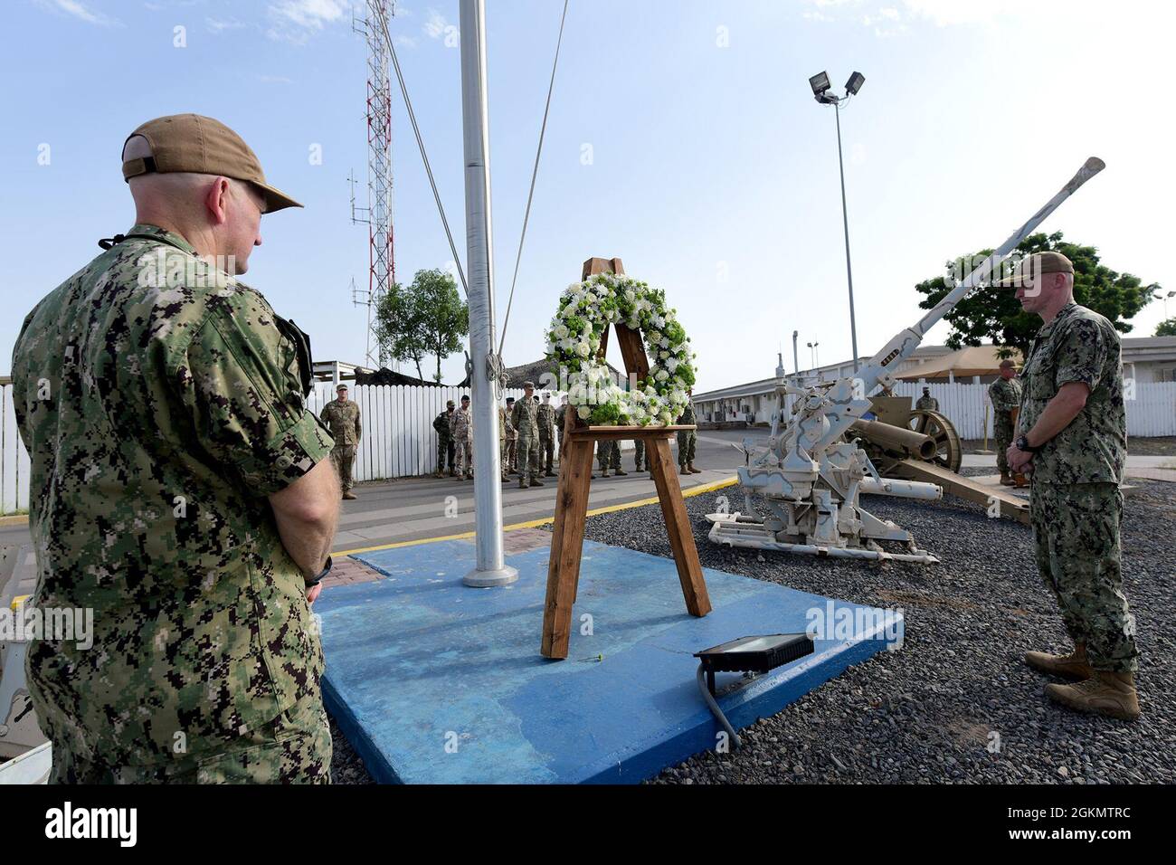 CAMP LEMONNIER, Dschibuti (31. Mai 2021) Camp LemonnierKommandierender Offizier der US-Marine Kapitän Kyle D. Schuman und sein Nachfolger, Capt. David Faehnle, zeigen während eines Schweigemingens während einer Gedenkfeierlichkeiten, die am 31. Mai 2021 in Camp Lemonnier zu Ehren der gefallenen Dienstmitglieder des Landes abgehalten wurden, ihre Achtung. Die Zeremonie um 8:00 Uhr ging voran, wobei alle Dienststellen in der heißen afrikanischen Sonne zur Aufmerksamkeit standen. Die Zeremonie beinhaltete Bemerkungen des Kommandanten des Offiziers der US-Marine, Kapitän Kyle D. Schuman, und eine Kranzniederlegung zu Ehren der Veteranen der Nation, die das ultimative Opfer darbrachten. Stockfoto