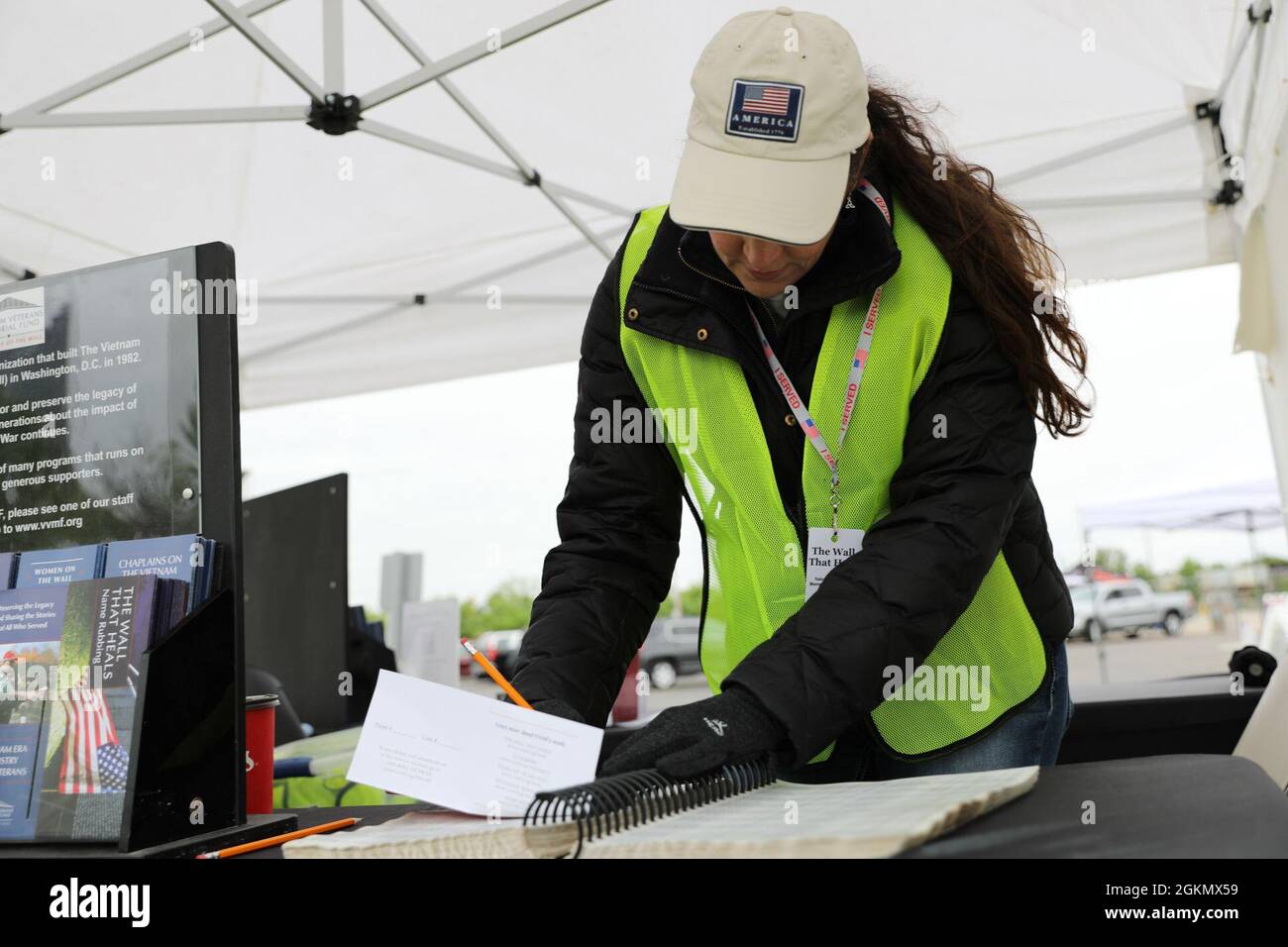 Karen Robertson, eine Freiwillige, sucht nach dem Namen eines Dienstmitglieds, um den Ort ihrer Gravur an der Mauer zu finden, die heilt, veranstaltet vom National Veterans Memorial Museum in Columbus, Ohio, 29. Mai 2021. Die Wand enthält Symbole, die anzeigen, ob ein Militärangehörter verstorben, vermutlich tot, vermisst oder inhaftiert ist. Stockfoto