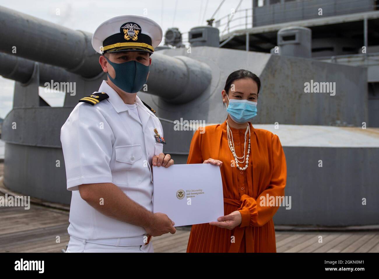 210602-N-HH215-1036 YOKOSUKA, Japan (2. Juni 2021) – Mary Ann Bagan erhält während einer Einbürgerungszeremonie an Bord des japanischen Gedenkschiffs Mikasa eine Einbürgerungsbescheinigung von LT. Andrew Decker, Leiter der Rechtsabteilung des Rechtsbüros der Region West Pacific. Während der Zeremonie wurden sieben Matrosen und Zivilisten aus der Elfenbeinküste, den Philippinen, Sierra Leone und Taiwan zu eingebürgerten Staatsbürgern der Vereinigten Staaten von Amerika. Stockfoto