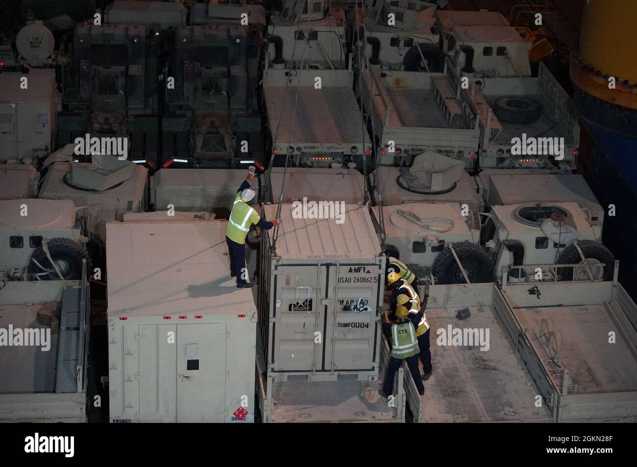 Hafenarbeiter von Shuaiba, Kuwait, sichern während des Schiffsbetriebs am 2. Juni 2021 Container auf dem Deck des Frachtschiffes Ocean Jazz. Soldaten des 1185. Einsatz- und Verteilungsunterstützungs-Bataillons der Army Reserve, Lancaster, Pennsylvania, überwachen diese Operationen, die die Reise zurück nach Fort Bliss, Texas, begannen, für die Fahrzeuge und Ausrüstung des Kampfteams der 2. Panzerbrigade, Soldaten der 1. Panzerdivision, die vor kurzem ihren Einsatz im Nahen Osten abgeschlossen haben. Stockfoto