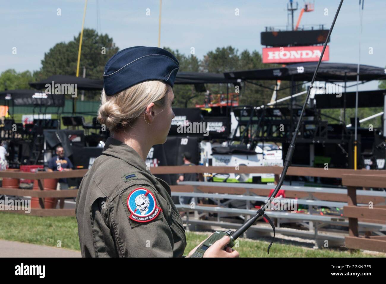 Oberleutnant Samanda McGiffin, Mitglied der 164. Airlift Squadron am 179. Airlift Wing, hält am 5. Juni 2021 ein Radio, um mit der Crew an Bord einer C-130 auf dem Mid-Ohio Sports Car Course zu kommunizieren. Der 179. Airlift Wing wurde von Mid-Ohio beauftragt, während der National Anthem eine C-130 über die Strecke zu fliegen. Stockfoto
