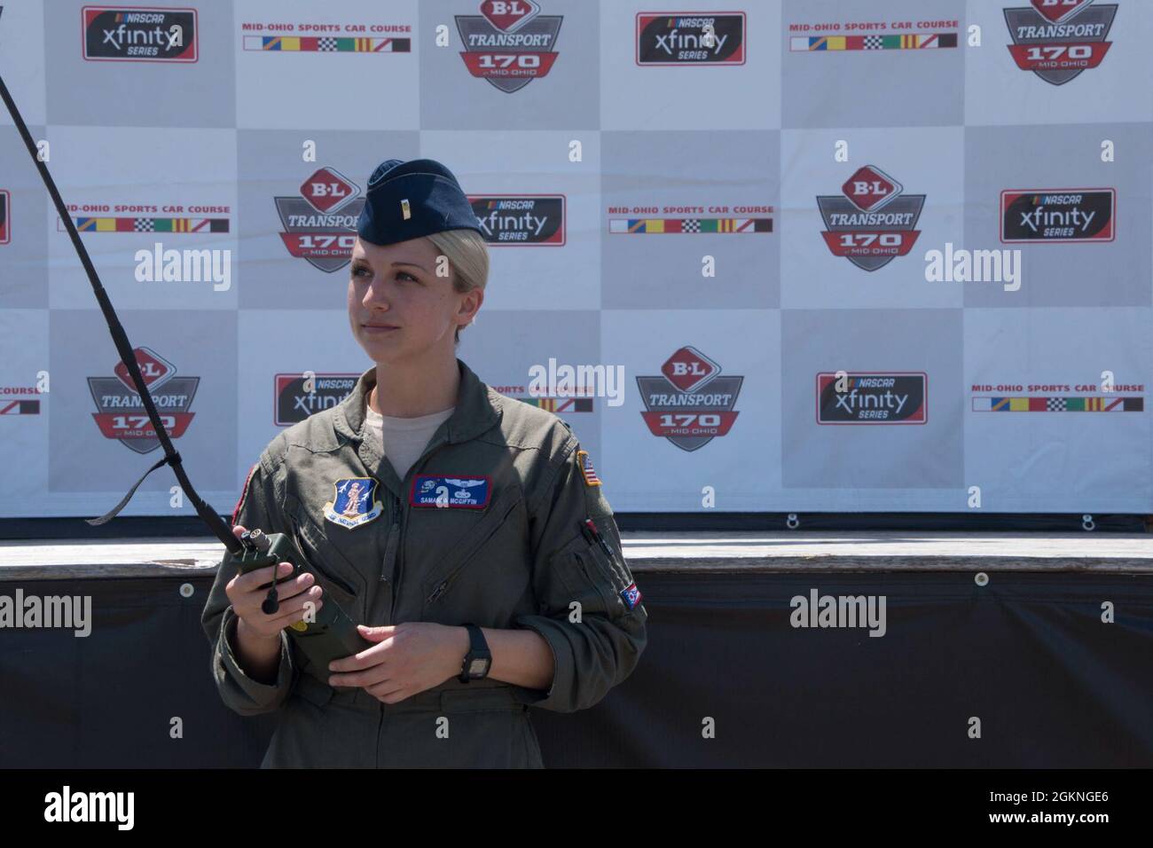 First Lieutenant Samanda McGiffin, ein Mitglied der 164. Airlift Squadron am 179. Airlift Wing, posiert mit einem Radio vor der Hauptbühne auf dem Mid-Ohio Sports Car Course am 5. Juni 2021. McGriffin diente während des Überfluges als Bodenkontrolle und kommunizierte mit der Crew im Flugzeug, um den Überflug mit der Leistung der Nationalhymne zu zeitlich zu planen. Stockfoto