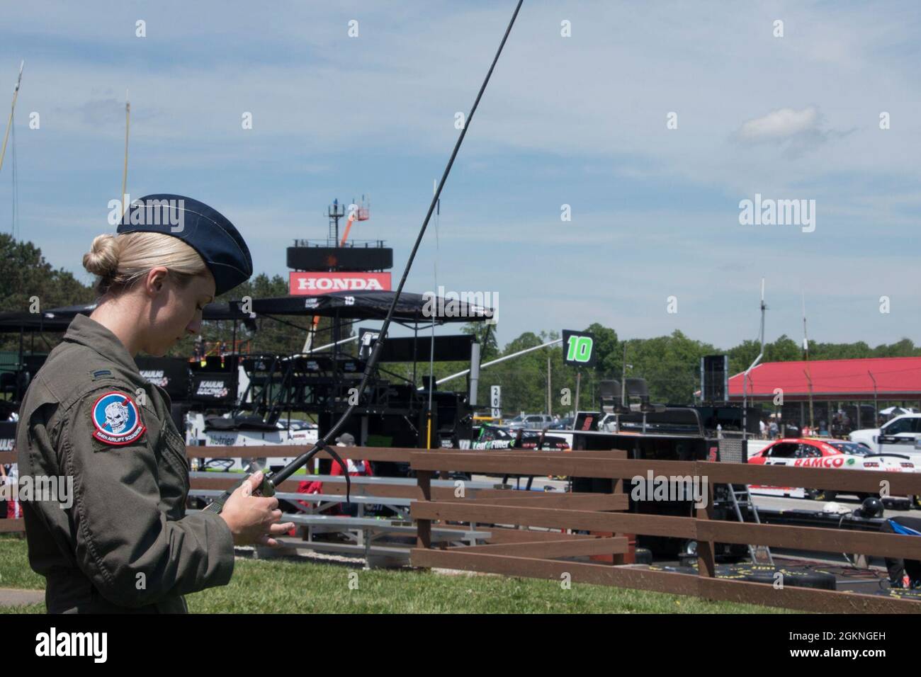 Oberleutnant Samanda McGiffin, Mitglied der 164. Airlift Squadron am 179. Airlift Wing, hält am 5. Juni 2021 ein Radio, um mit der Crew an Bord einer C-130 auf dem Mid-Ohio Sports Car Course zu kommunizieren. Der 179. Airlift Wing wurde von Mid-Ohio beauftragt, während der National Anthem eine C-130 über die Strecke zu fliegen. Stockfoto