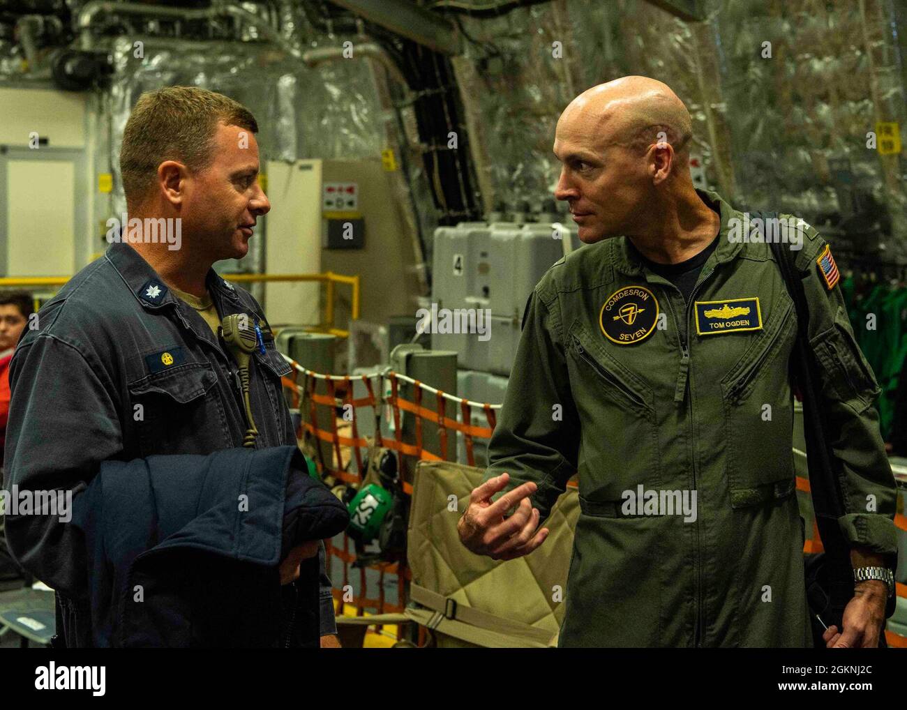 PHILIPPINISCHES MEER (6. Juni 2021) Cmdr. Brandon J. Cornes, links, kommandierender Offizier des Litoral Combat Ships USS Tulsa (LCS 16), begrüßt Capt. Tom Ogden, commodore von Destroyer Squadron (DESRON) 7, am Ende der Flugoperationen in der Hanger Bay des Schiffes. Tulsa, Teil von DESRON 7, ist im 7. Flottenbereich der USA im Einsatz, um die Interoperabilität mit Partnern zu verbessern und als einsatzbereite Kraft zur Unterstützung einer freien und offenen Region im Indo-Pazifik-Raum zu fungieren. Stockfoto