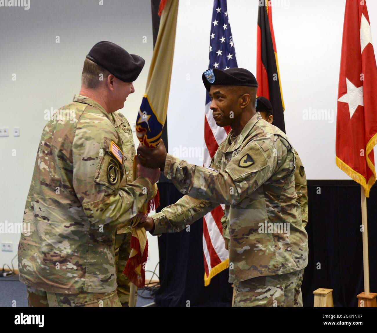 Der ausscheidende Kommandant der U.S. Army, Freddy L. Adams II, 409. Contracting Support Brigade (rechts), übergibt die Farben an den Generalmajor Christopher Mohan, 21. Theater Sustainment Command, der während einer Befehlswechselzeremonie am 7. Juni 2021 in Sembach, Deutschland, kommandiert. Col. Jarrett S. Moffitt übernahm das Kommando über die Einheit von Adams II. Stockfoto