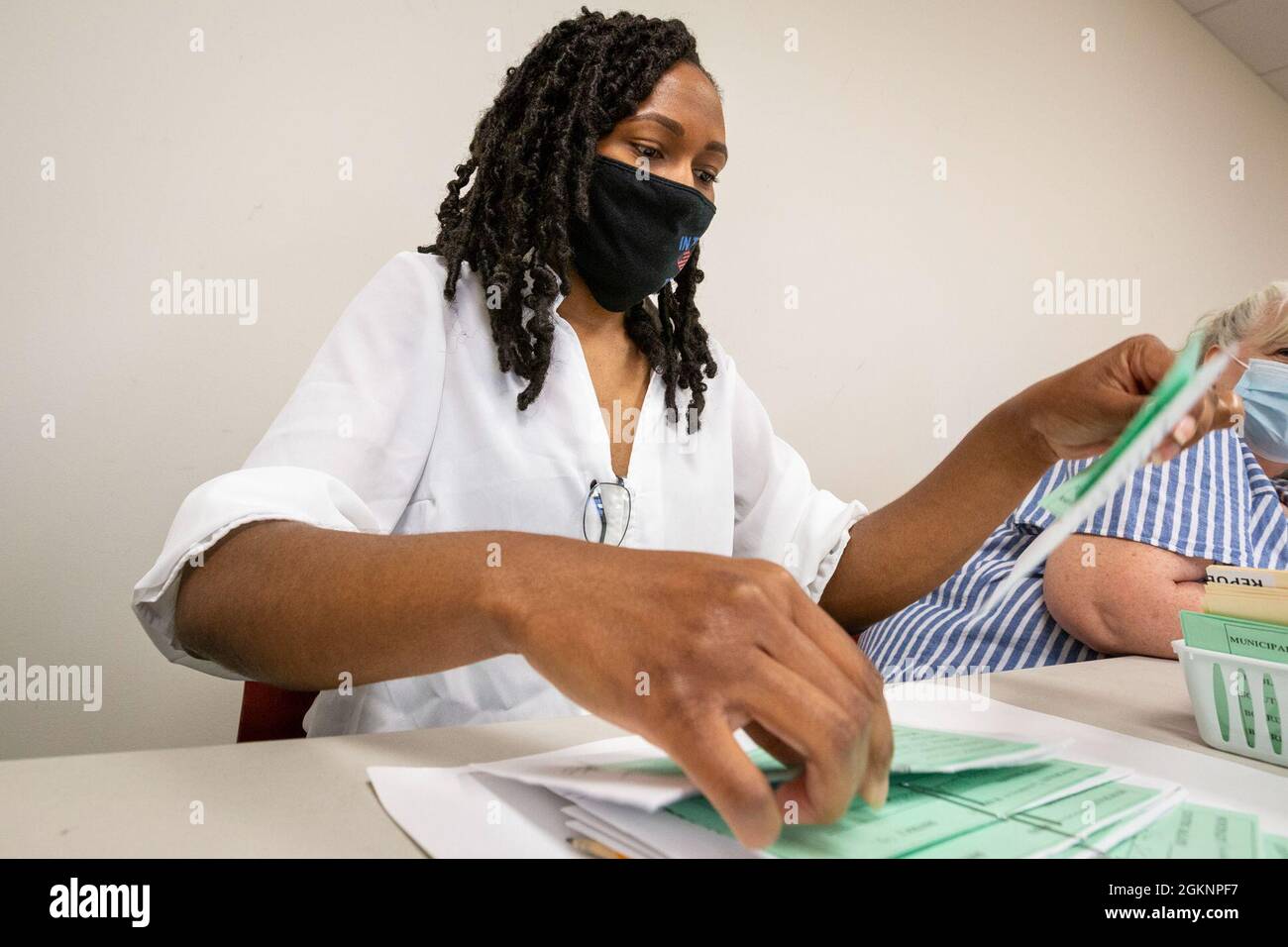 Andrea A. Williamson, Senior Airman der US Air Force, 108. Flügel der New Jersey Air National Guard, trennt die Stimmzettel im Board of Elections Office, Mount Holly, N.J., 8. Juni 2021. Mehr als 600 Mitglieder der Nationalgarde von New Jersey kamen auf Antrag der Wahlbehörden in 15 Bezirken von New Jersey zur Wahl. Nach der erfolgreichen Unterstützung der Garde bei den Primär- und Parlamentswahlen 2020 mobilisierten sich Bürgersoldaten und Bürgerflieger während der Primary des Staates New Jersey 2021 erneut, um zivilen Umfragearbeitern und Bezirkspersonal zu helfen. Stockfoto