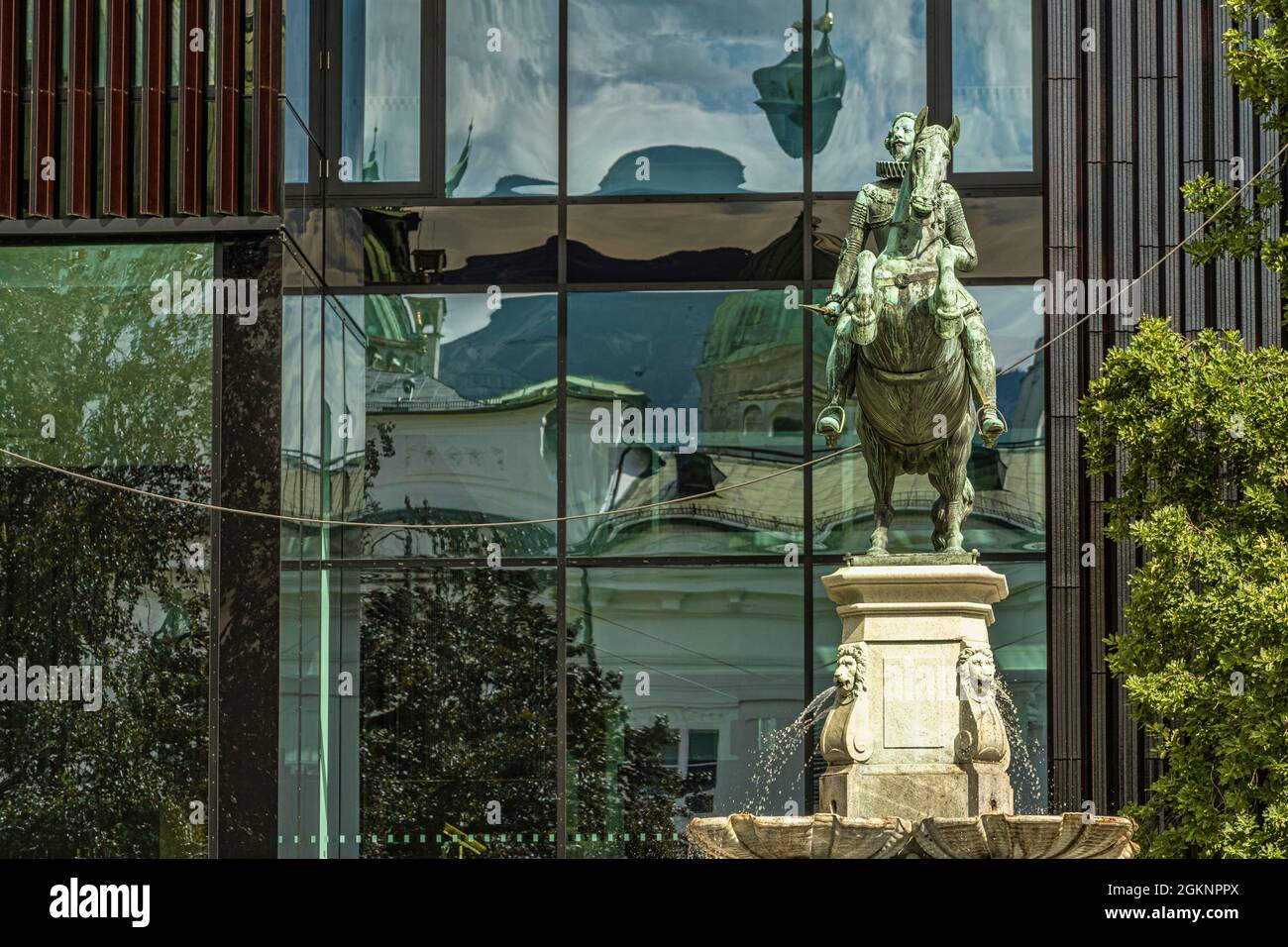 Springbrunnen mit einer Reiterstatue, die Leopold Brunnen gewidmet ist. Hinter den Fenstern des Hauses der Musik in Innsbruck. Innsbruck, Tirol, Österreich Stockfoto