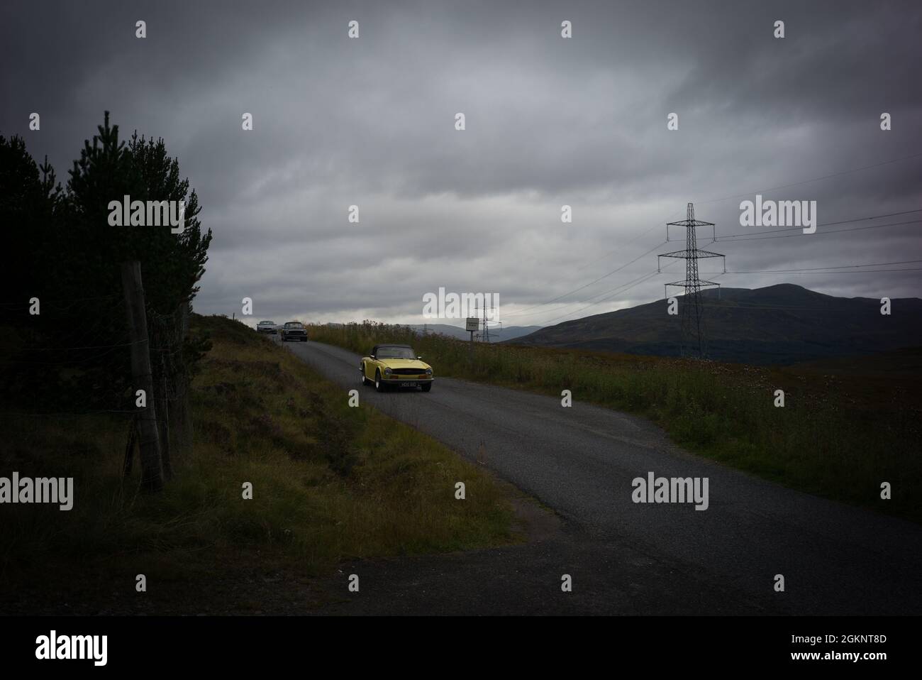 Triumph TR6 fährt durch Glen Garry, Schottische Highlands Stockfoto