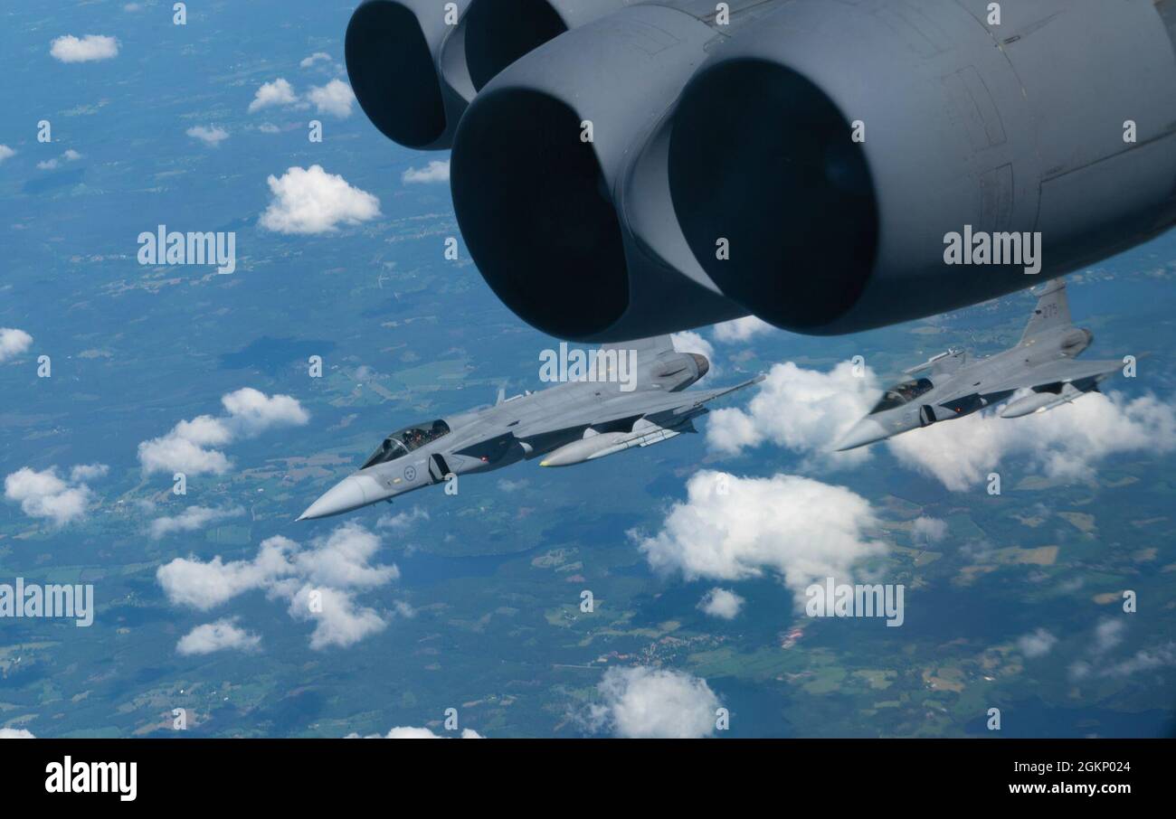 Zwei schwedische Saab JAS-39 Gripen-Kampfflugzeuge begleiten eine B-52H-Stratofortress während eines Bomber Task Force Europe 21-3-Fluges auf dem Weg zu einem maritimen Trainingsszenario am 09. Juni 2021 über Europa. Bombermissionen demonstrieren die Glaubwürdigkeit unserer Kräfte, um ein globales Sicherheitsumfeld zu bewältigen, das vielfältiger und unsicherer ist als zu jeder anderen Zeit in unserer Geschichte. Stockfoto