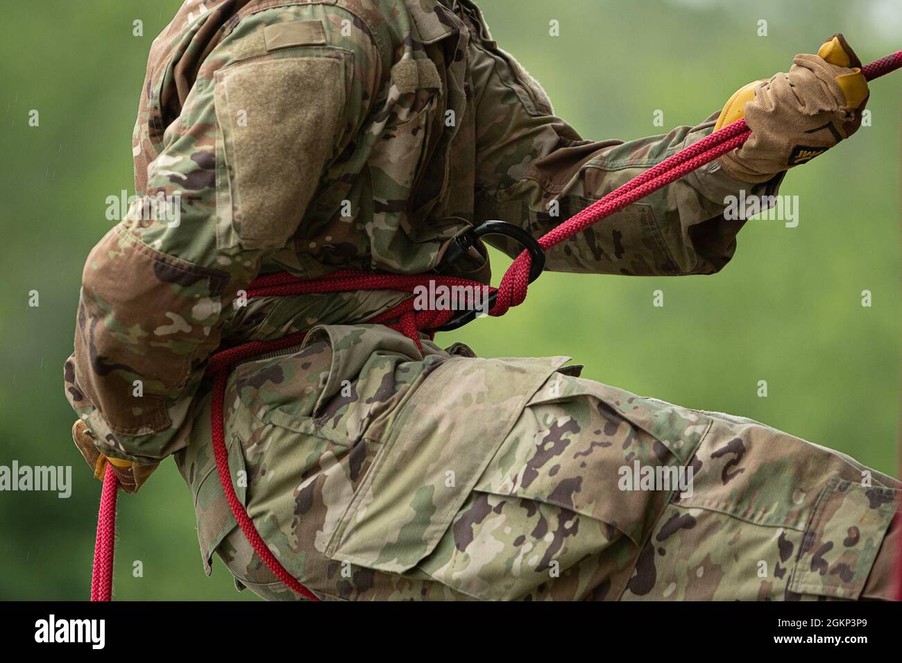 Zum Abseilen führt ein Seil durch einen verriegelenden Karabiner, der, wenn er richtig verwendet wird, Reibung erzeugt, um den Abseiler sicher auf den Boden zu senken. | Foto von Army Staff Sgt. Alexander Henninger Stockfoto