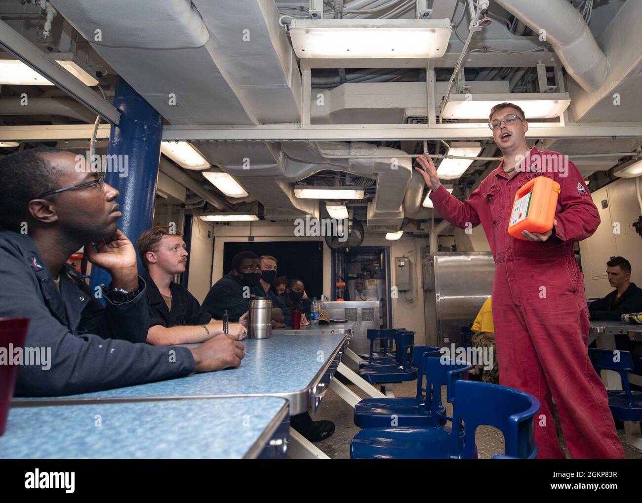 Damage Controlman 2nd Class Spencer Jones aus Chicago, der der Ingenieurabteilung des Arleigh Burke-Klasse-Lenkungszerstörers USS Lassen (DDG 82) zugewiesen wurde, ermöglicht eine Kommandoindoktrinationsklasse auf dem Mess-Deck, 11. Juni 2021. Lassen ist im Gange im Atlantischen Ozean und unterstützt USS Gerald R. Ford’s (CVN 78) Full Ship Shock Trials. Die US Navy führt Schockversuche an neuen Schiffsdesigns mit Live-Sprengstoffen durch, um zu bestätigen, dass unsere Kriegsschiffe auch unter harten Bedingungen, denen sie im Kampf begegnen könnten, weiterhin anspruchsvolle Missionsanforderungen erfüllen können. Stockfoto