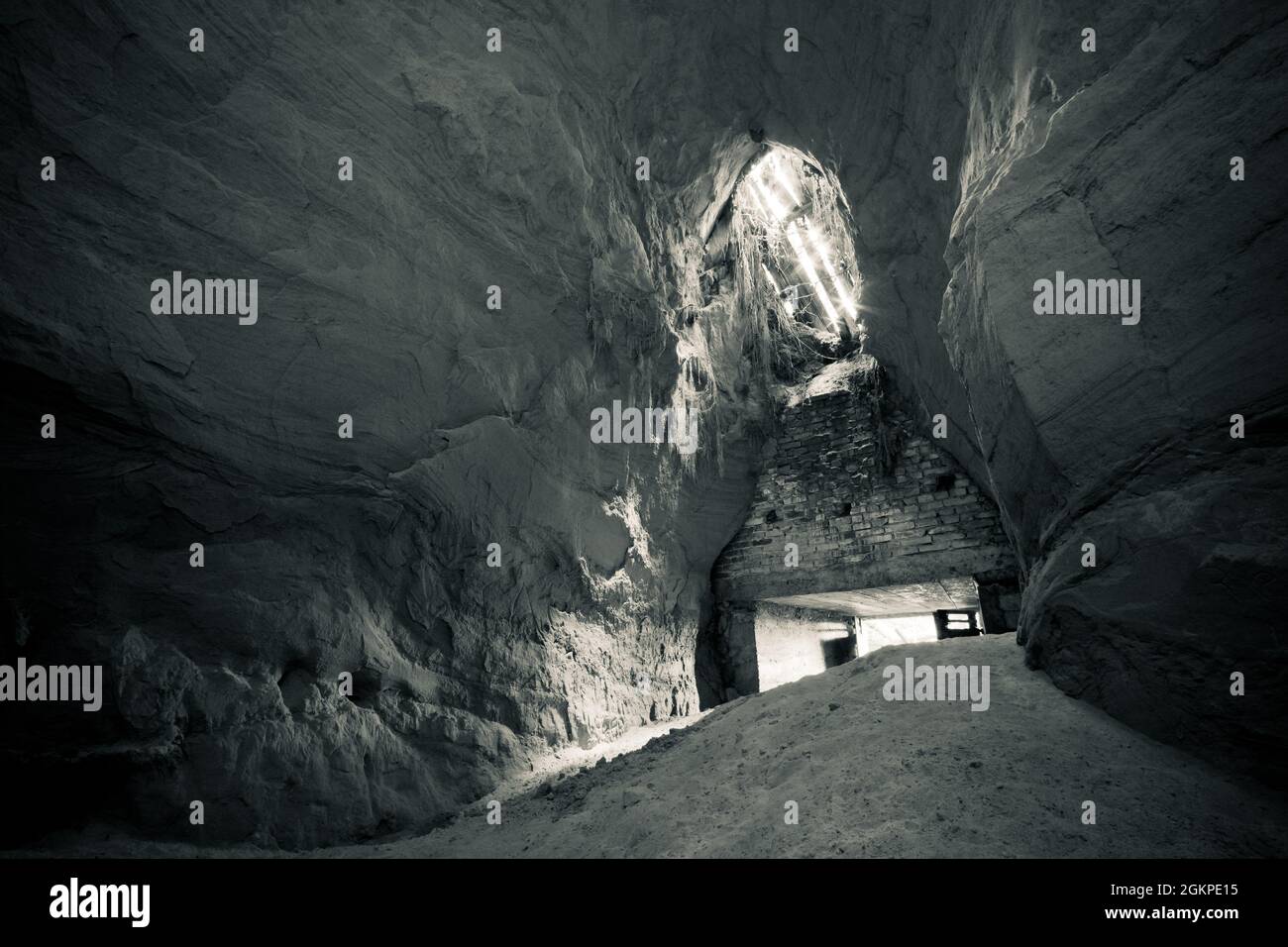 Ein alter verlassene Sandsteinkeller, eine versteckte Höhle im Wald, die in der Vergangenheit zur Lagerung genutzt wurde Stockfoto