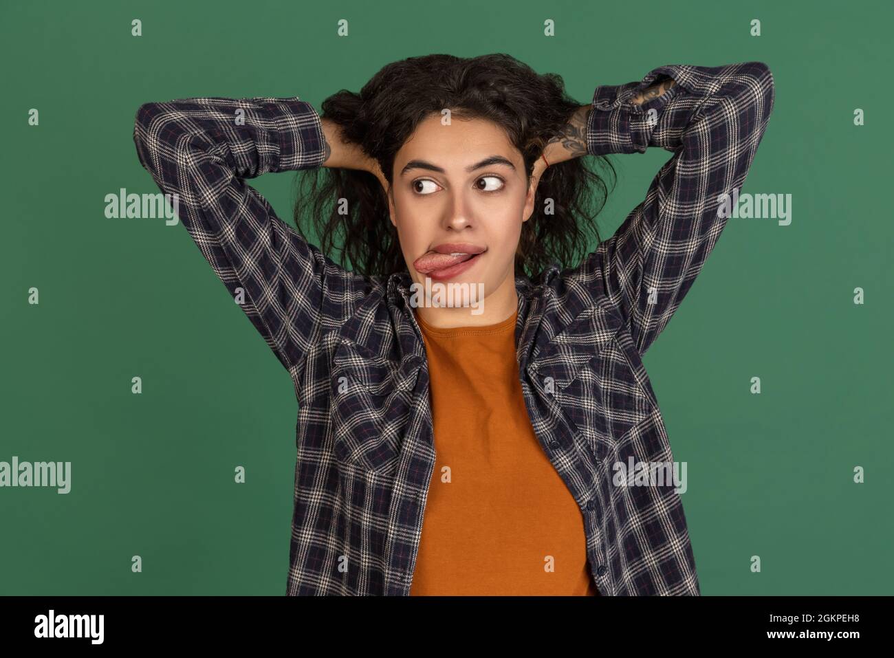 Gesichter machen. Portrait von Latino schönes Mädchen isoliert auf grünen, vintage Farbe Studio Hintergrund. Konzept der menschlichen Emotionen Stockfoto