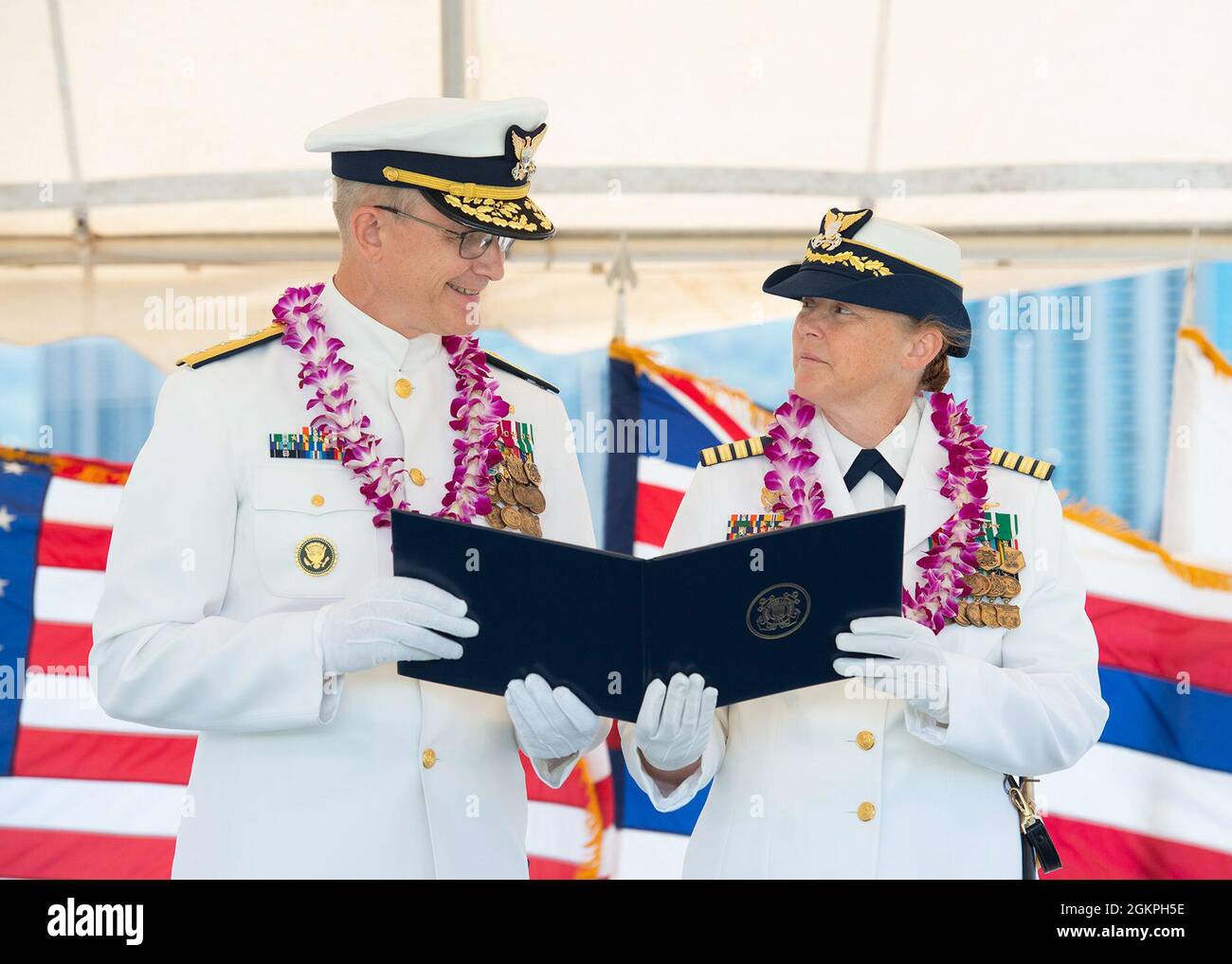 Hinterer Adm. Peter Gautier, stellvertretender Kommandant der Küstenwache im pazifischen Raum, überreicht Capt. Holly Harrison während einer Zeremonie zur Änderung des Kommandos auf der Küstenwache in Honolulu, 14. Juni, 2021. Während der Befehlswechselzeremonie wurde Harrisons kommandierender Offizier des Küstenwachtschneiderei Kimball von Kapitän Thomas D'Arcy entlastet. Stockfoto