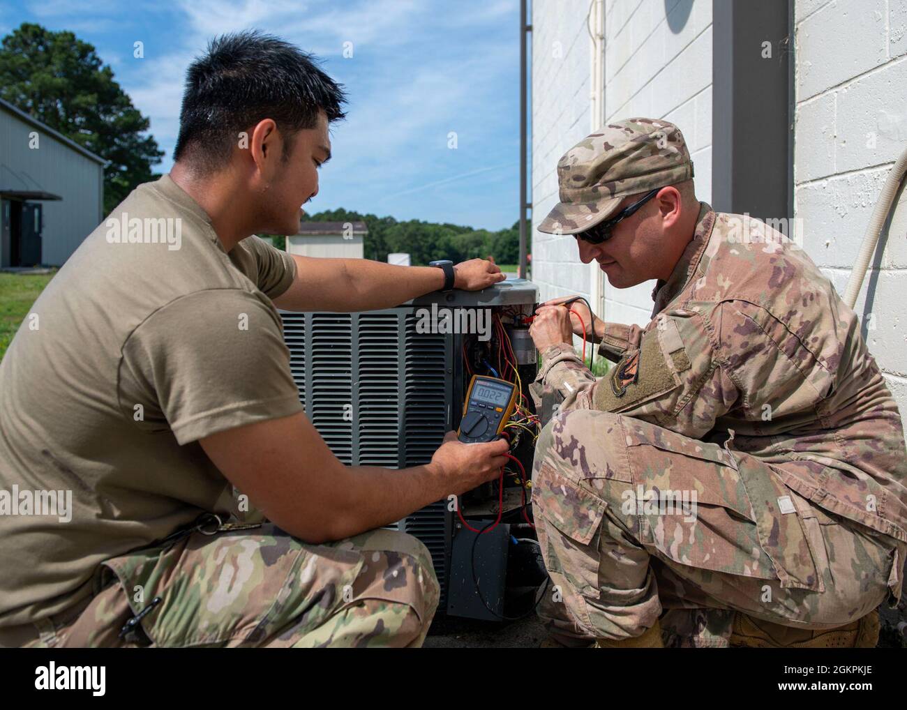 Senior Airman Joje Masaganda, links, und Staff Sgt. Mitchell Cole, 4. Bauingenieur der Geschwader für Heizung, Lüftung, Klimaanlage und Kühlung, verwendet ein Multimeter, um die Komponenten einer Split-System-Klimaanlage auf Leistungsverlust zu überprüfen. Das Gerät wurde am Luftwaffenstützpunkt Seymour Johnson, North Carolina, 14. Juni 2021, eingesetzt. Masaganda und Cole fanden einen defekten Schütz und ersetzten ihn. Stockfoto