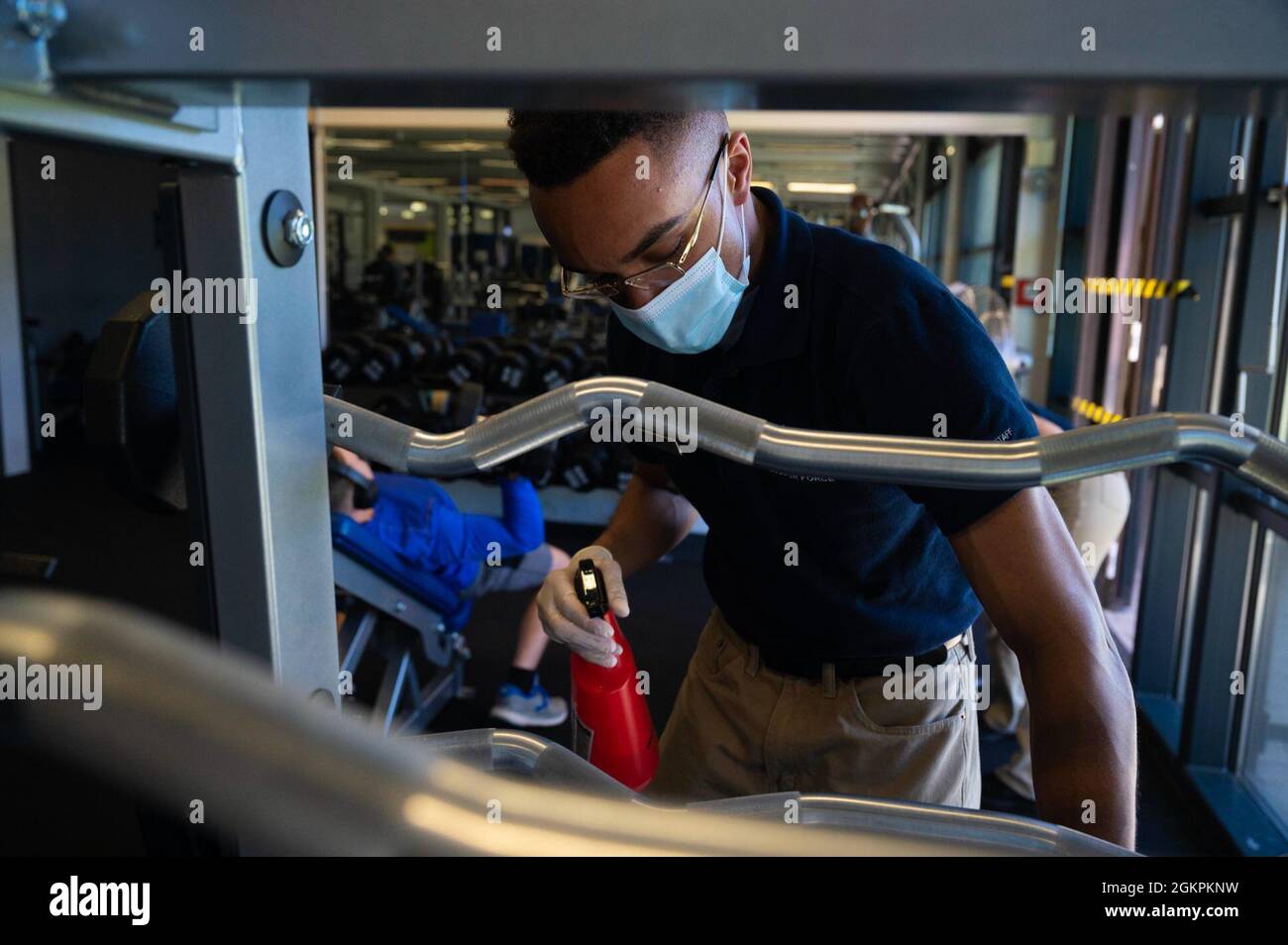 Luke Winston, Airman der US-Luftwaffe, 786th Force Support Squadron Fitness-Geselle, desinfiziert Fitnessgeräte auf dem Ramstein Air Base, Deutschland, 14. Juni 2021. Winston wischt jedes Fitnessgerät ab, um das Risiko von COVID-19 und anderen Bakterien zu mindern. Stockfoto
