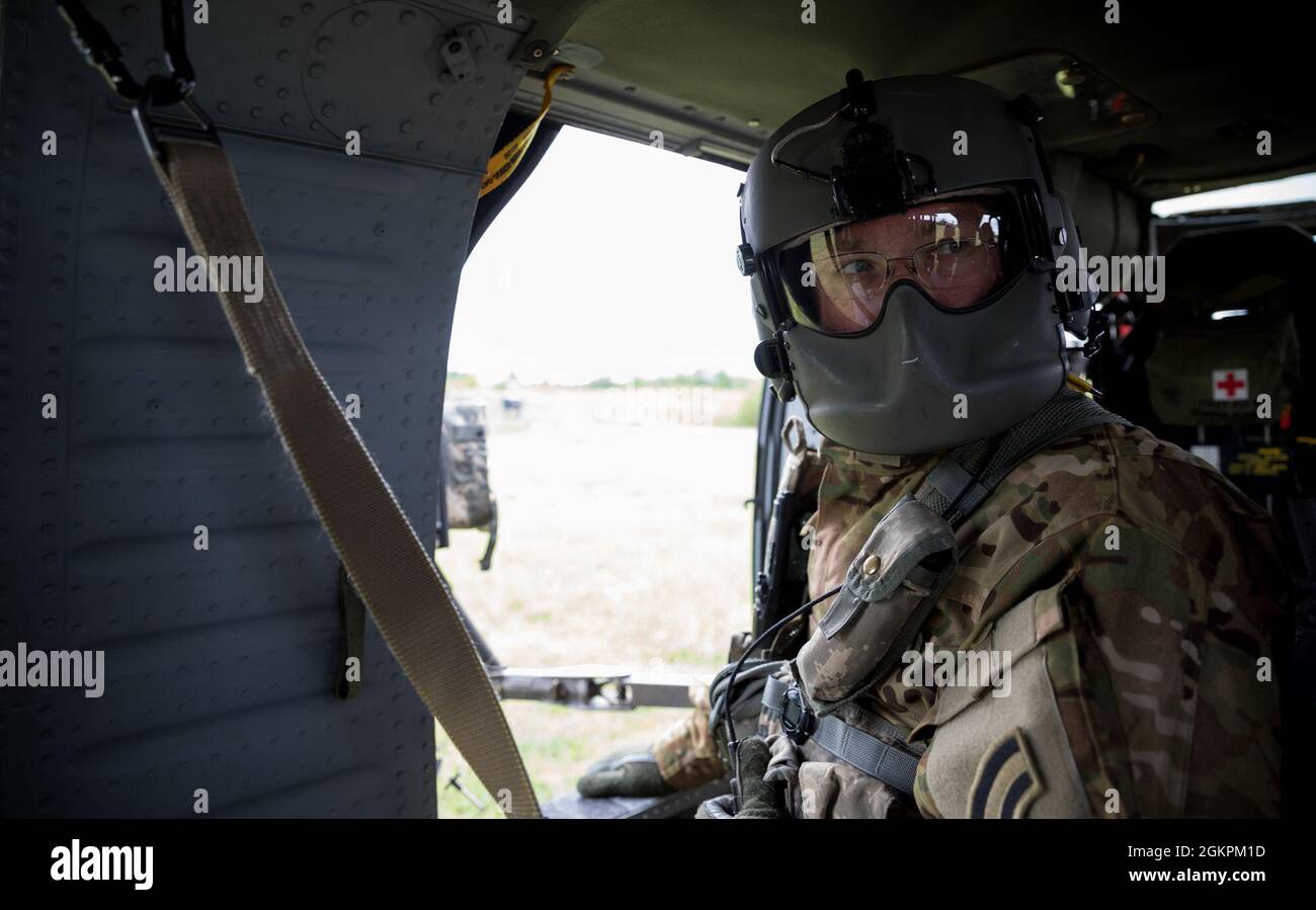 Sgt. Richard Wooten, ein Crewchef der Charlie Company, 3. Bataillon, 142. Luftfahrtregiment, blickt während eines Flugbeschußtrainings im Range 48, Fort Drum, New York, an Bord eines Hubschraubers der UH-60 Black Hawk 2021 über seine Schulter. Wooten trägt ein Integriertes Helmsystem der Aircrew HGU-56/P mit Maxillofacial Shield oder MFS, das das Gesicht vor Rotorwäsche und Schmutz schützt. Stockfoto