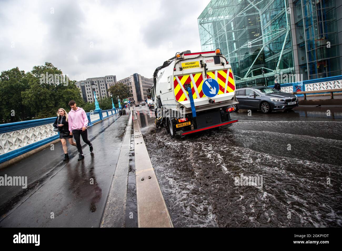 Ein Wartungsfahrzeug verwendet eine Vakuumpumpe, um Hochwasser auf der Tower Bridge aufzusaugen. Stockfoto