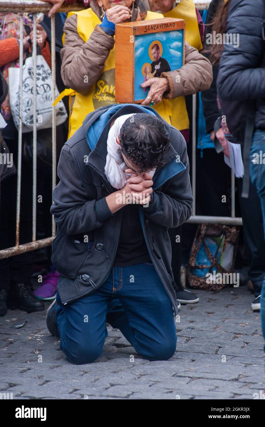 BUENOS AIRES, ARGENTINIEN - 08. Aug 2018: Eine vertikale Aufnahme des Mannes, der während der Messe des heiligen Cletan in Buenos Aires im Gebet kniet. Stockfoto