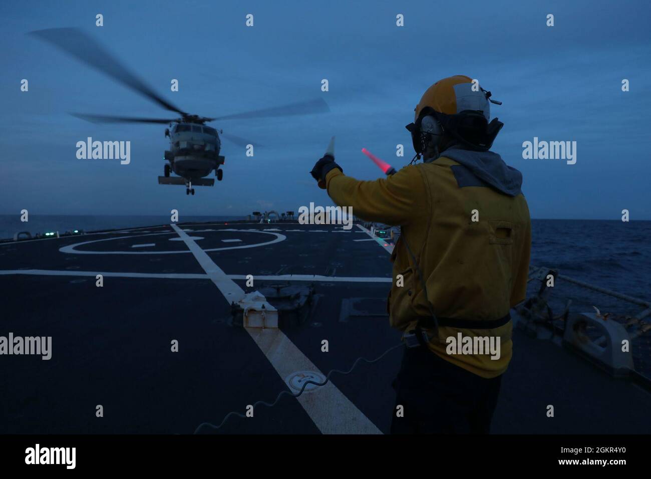 ATLANTISCHER OZEAN (17. Juni 2021) Cody Johannes, der dem Lenkflugkörper-Zerstörer USS Ross (DDG 71) der Arleigh Burke-Klasse zugewiesen wurde, signalisiert einem spanischen SH-60 Seahawk, am 17. Juni 2021 auf dem Schiffsdeck im Atlantischen Ozean zu landen. Ross, der im spanischen Rota stationiert ist, ist auf Patrouille im Einsatzgebiet der Sechsten Flotte der USA, um regionale Verbündete und Partner sowie nationale Sicherheitsinteressen der USA in Europa und Afrika zu unterstützen. Stockfoto