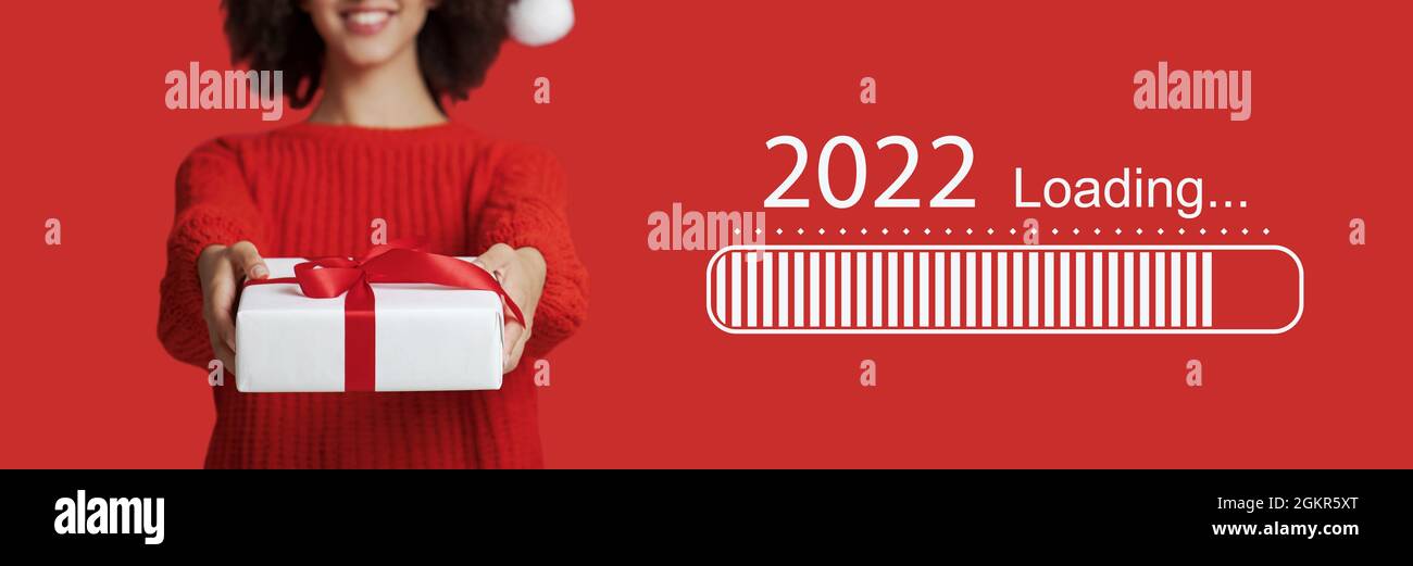 Junge schwarze Frau im Weihnachtshut, Weihnachtsgeschenk auf rotem Hintergrund, Collage mit 2022 Ladeprozesstab Stockfoto