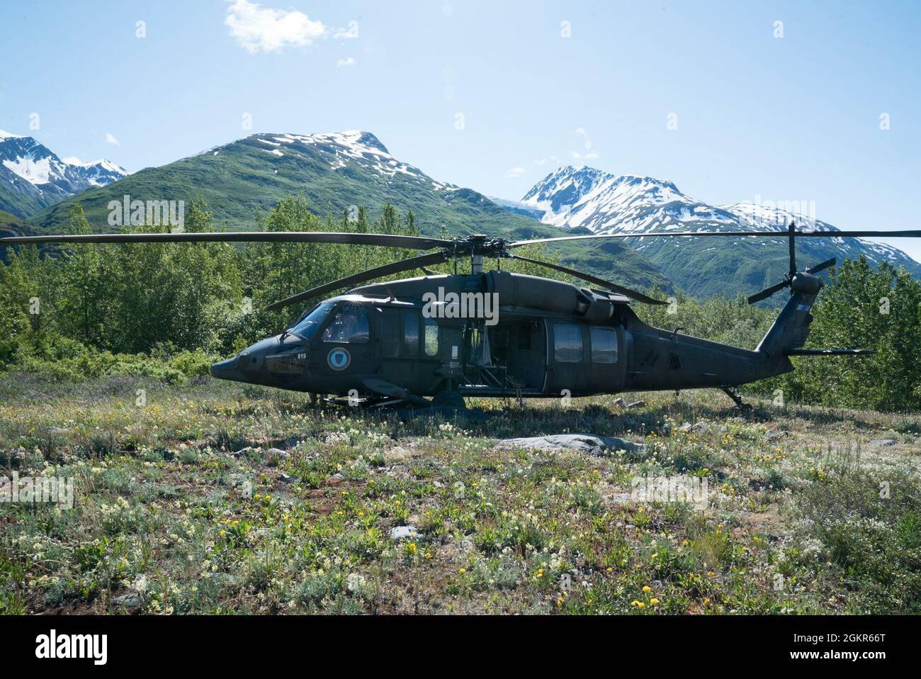 Ein Hubschrauber der Alaska Army National Guard UH-60 Black Hawk sitzt am Fuß der Chugach Mountain Range, Alaska, nachdem er an einem abgelegenen Wetterbeobachtungsposten gelandet ist, um Lieferungen zur Unterstützung der Operation Colony Glacier am 17. Juni 2021 zu liefern. Die Operation Colony Glacier ist ein Versuch, die Überreste von Dienstmitgliedern und Wracks eines C-124-Flugzeuges, das im November 1952 mit 52 Militärmitgliedern an Bord gelandet war, zu retten. Das Wrack wurde 2012 entdeckt und jeden Sommer findet eine Erholung statt. Dies wird das neunte Jahr der Wiederauffüllungsbemühungen sein. Stockfoto