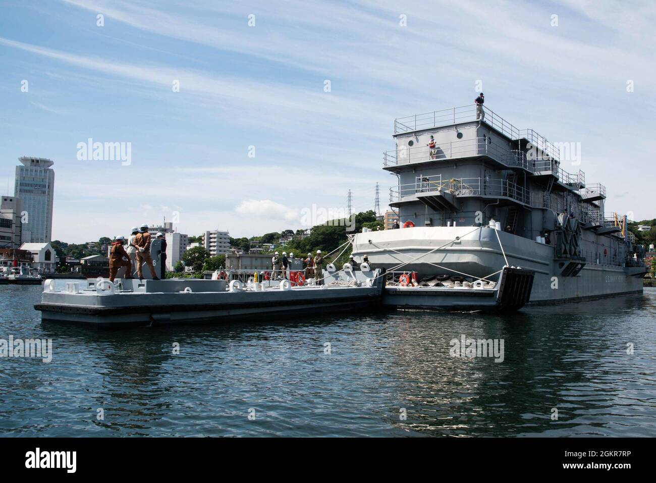 YOKOSUKA, Japan (18. Juni 2021) Kommandant, Flottenaktivitäten Yokosuka (CFAY) Port Operations Boatteams unterstützen eine Trockendockentwicklung der Floating Workshop YR 85 für Reparaturen und Wartung in CFAY's Dry Dock #2, das ursprünglich 1884 gebaut wurde. Sobald die Barge an ihrem Platz war, wurde die Trockendock entwässert, so dass die Arbeiter vollen Zugang zu allen Teilen der Barge zur Reparatur hatten. Seit mehr als 75 Jahren stellt, pflegt und betreibt CFAY Basiseinrichtungen und -Dienste zur Unterstützung der im Einsatz kommenden Seestreitkräfte der 7. US-Flotte, der Pächter-Kommandos und Tausender militärischer und ziviler Mitarbeiter Stockfoto