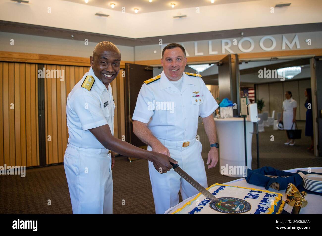 Hinterer Adm. Stephen Barnett, scheidender Kommandant, aus Columbia, Tennessee und dem hinteren ADM. Brad Collins, neuer Kommandant der Navy Region Northwest, Schnitt nach einer Befehlswechselzeremonie auf dem Marinestützpunkt Kitsap-Bangor am 18. Juni einen feierlichen Kuchen. Während der Zeremonie entlastete Collins aus Lake Forest, Kalifornien, Barnett, Als Kommandant, Navy Region Northwest. Stockfoto