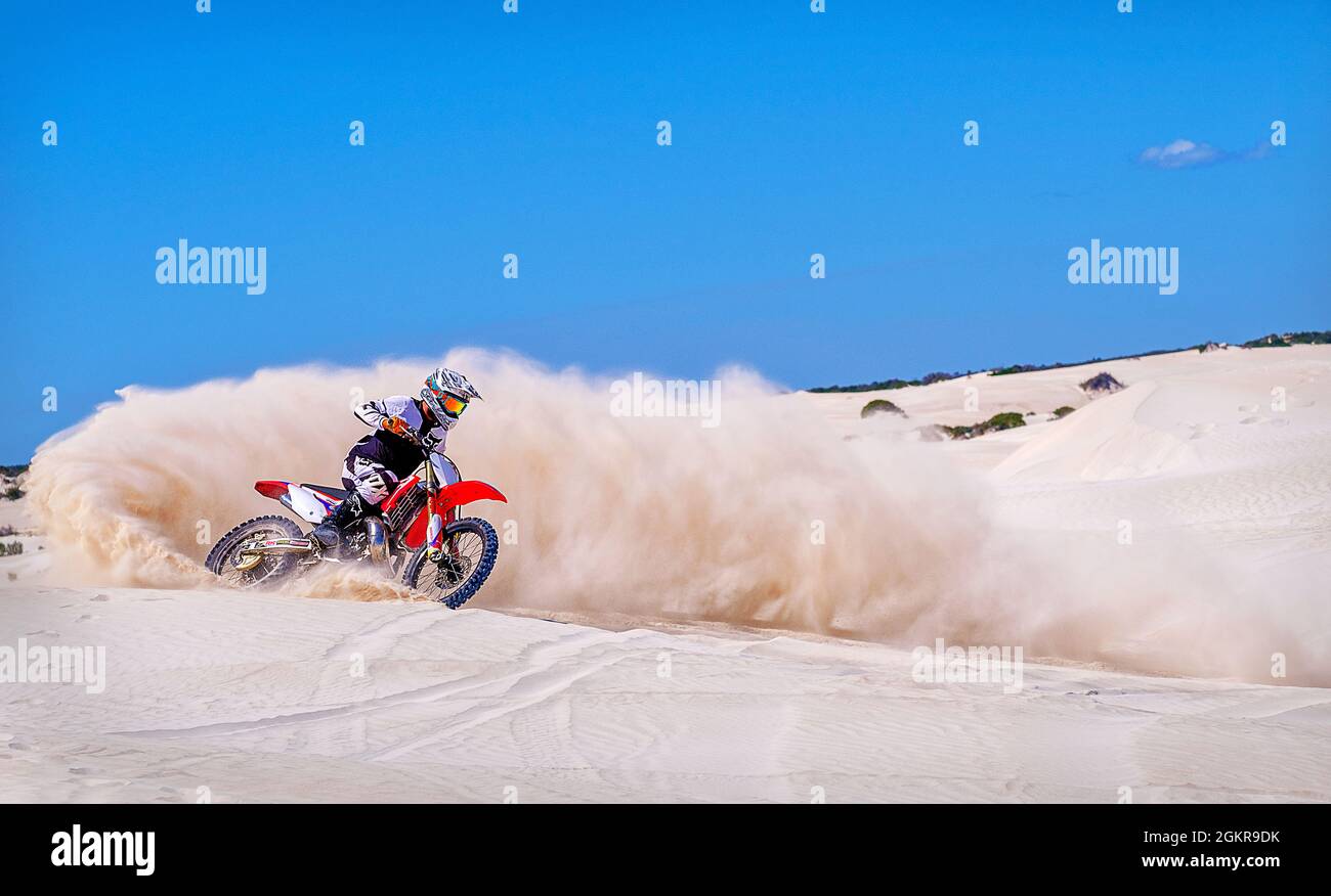 Trial Bike Rider kicking up Sand an den Sanddünen von Lancelin, Western Australia, Australien, Pazifik Stockfoto