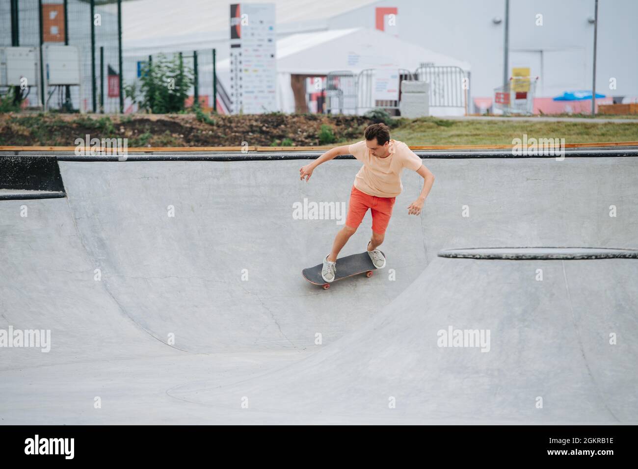 Speedy Mann Skater in bunten Kleidern Reiten auf ihrem Brett auf Viertel Rohr Kreis Stockfoto Speedy Mann Skater in bunten Kleidern Reiten auf ihrem Brett auf Viertel Rohr Kreis Stockfoto