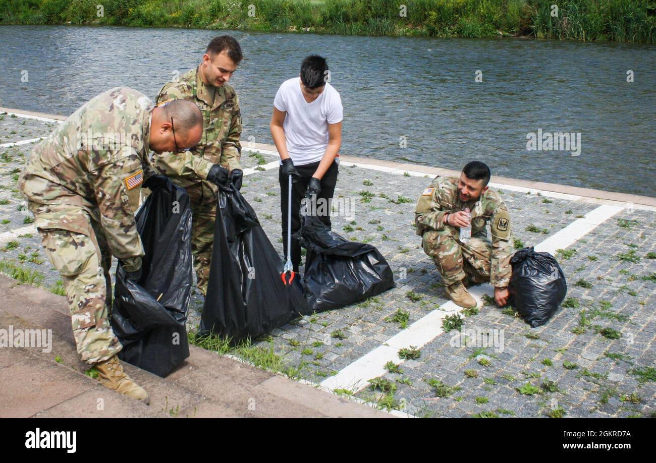 Am 19. Juni 2021 sammeln US-Soldaten, die dem Regionalkommando Ost, der Kosovo-Streitkräfte und einem lokalen Bewohner zugewiesen sind, Müll entlang einer Brücke in Mitrovica/Mitrovicë, Kosovo. Mehr als 40 Menschen halfen freiwillig bei der Säuberung, darunter US-Soldaten und Schweizer Soldaten sowie Bewohner aus Nord- und Süd-Mitrovica/Mitrovicë. Stockfoto