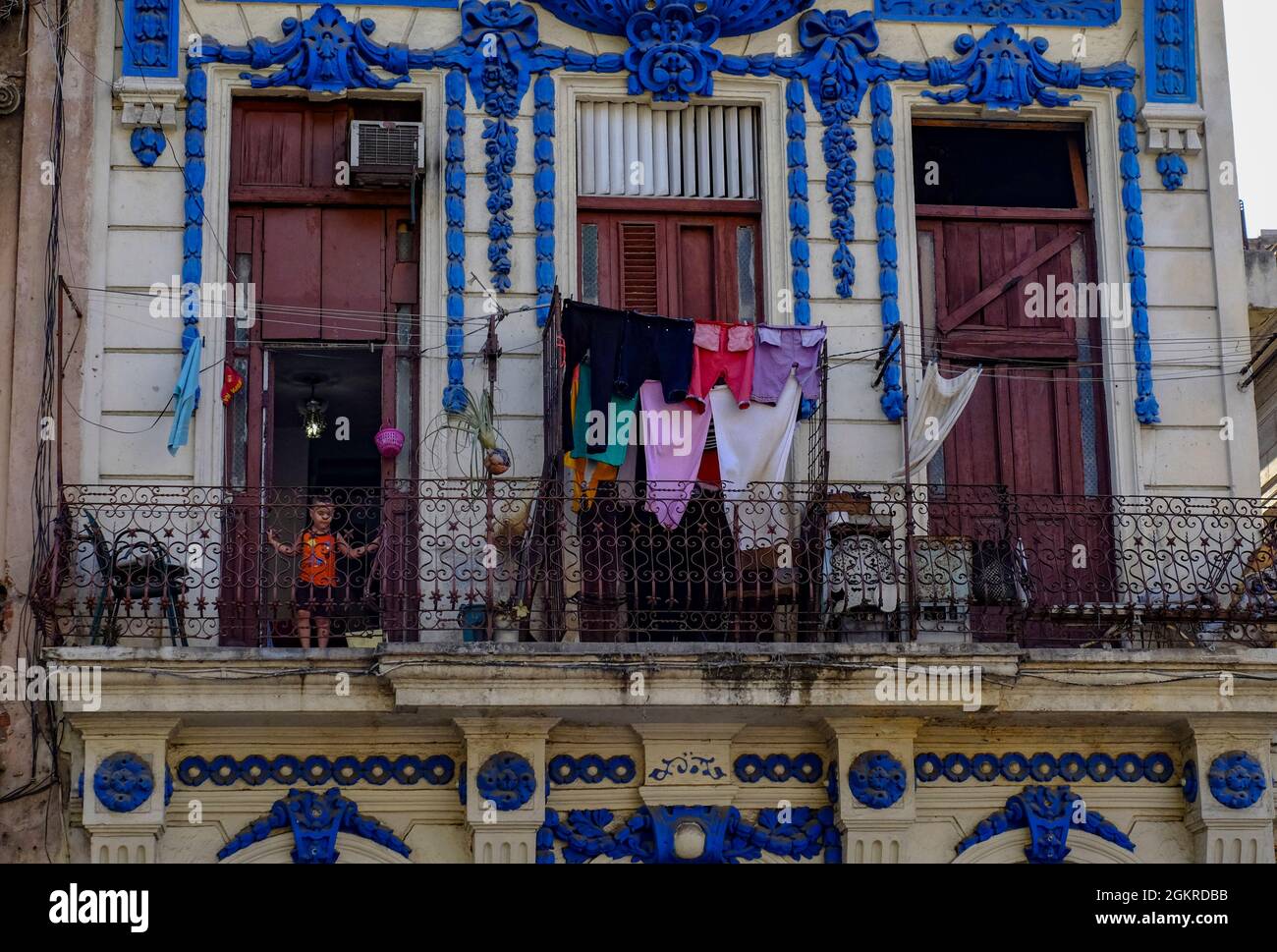 Kleines Kind in der Tür auf dem Balkon mit trocknenden Kleidern, Havanna, Kuba, Westindien, Mittelamerika Stockfoto