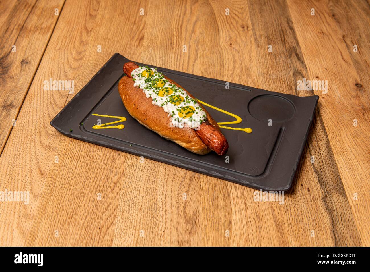 Hot Dog mit Tartarsauce, Senfsauce und Schnittlauch Stockfoto