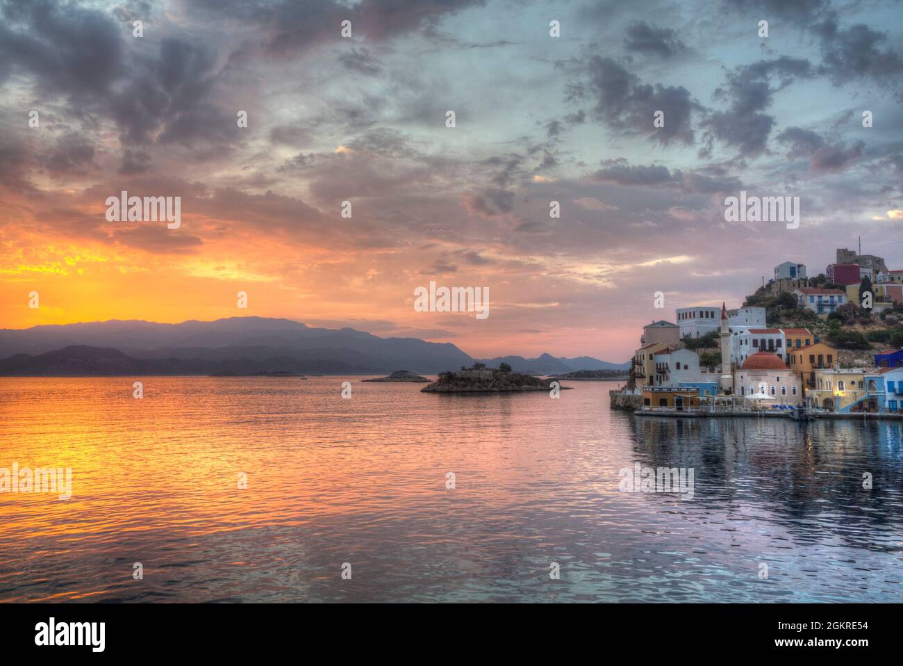 Sonnenaufgang, Gebäude am Hafeneingang, Kastellorizo (Megisti) Island, Dodecanese Group, Greek Islands, Greece, Europa Stockfoto