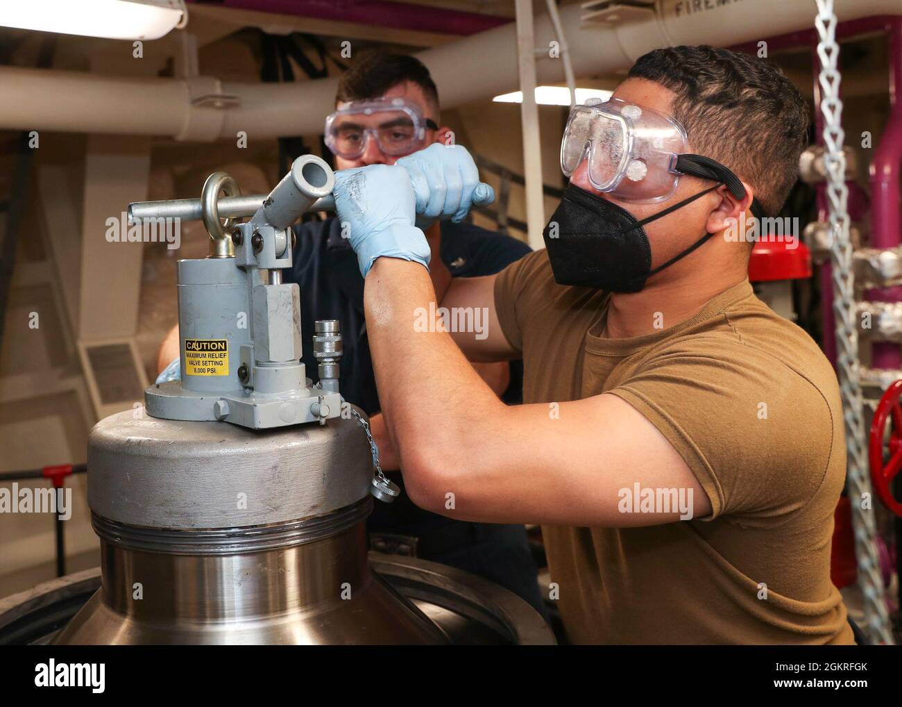 210621-N-NM271-1132 PAZIFISCHER OZEAN (21. Juni 2021) – Aviation Boatswain’s Mate (Fuels) Airman Deion Mesa, rechts, aus Tahlequah, Okla., und Aviation Boatswain’s Mate (Fuels) 3rd Class Brandon Mills, aus Edgewood, Iowa, demontieren einen Treibstoffreiniger an Bord des amphibischen Angriffsschiffs USS Tripoli (LHA 7), Juni 21. Tripolis führt derzeit Routineoperationen in der dritten US-Flotte durch. Stockfoto