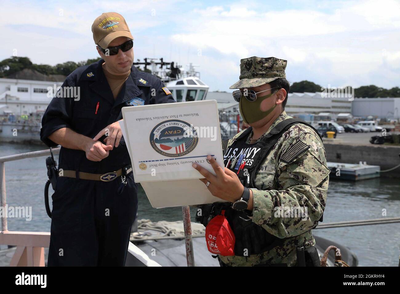 YOKOSUKA, Japan – Command Master Chief Kevin Swanson, Los Angeles-Klasse Schnellangriff-U-Boot USS Oklahoma City (SSN 723) Chief of the Boat, erhält einen Besuch Schiff Brief von Master-at-Arms 2. Klasse Ignacio Fuentes als Oklahoma City ankommt Flotte Aktivitäten Yokosuka für einen planmäßigen Hafenbesuch, Juni 22. Oklahoma City wird nach Guam entsandt und arbeitet routinemäßig in der Region, um nationale Sicherheitsinteressen zu unterstützen und maritime Sicherheitsoperationen durchzuführen. Stockfoto