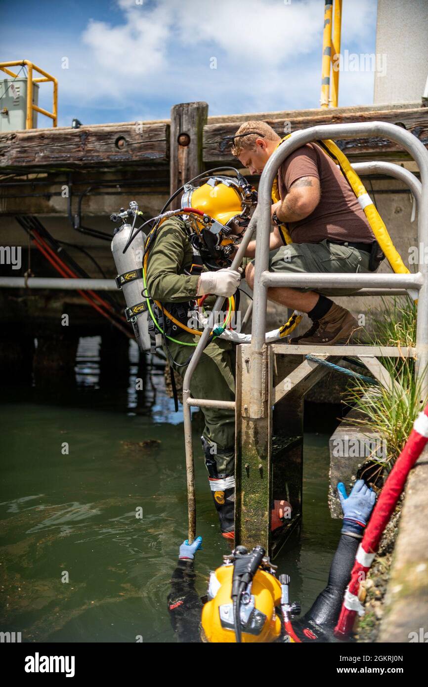 VIRGINIA BEACH, VA. – (21. Juni 2021) Navy Diving 2nd Class Matthew McDorman pflegt den Navy Diving 2nd Class Jared Leestma, während er Tauchoperationen an der Oberfläche durchführt. Beide sind der Mobile Diving Salvage Unit (MDSU) 2, Firma 2-5, zugeordnet. MDSU 2, gegründet von der Joint Expeditionary Base Little Creek - Fort Story, ist eine kampfbereite Expeditionstruppe, die weltweit zur Unterstützung aller Tauch- und Bergungsoperationen eingesetzt werden kann. Stockfoto