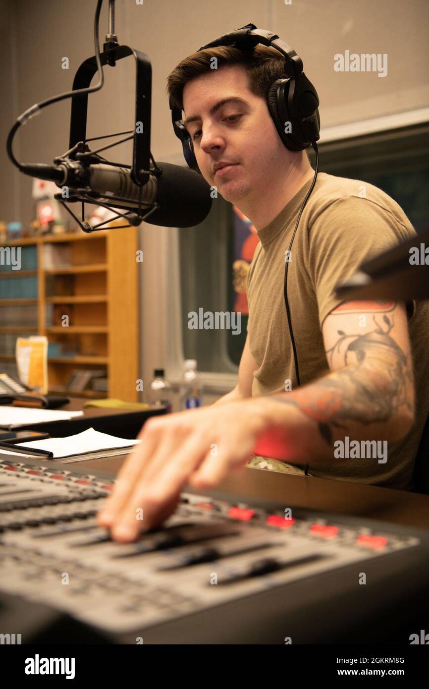 Personal Sgt. Samuel Burns, ein Rundfunkjournalist vom American Forces Network-Tokyo, passt die Mikrofonlautstärke an, während er „Shogo Radio“ vom Flugplatz Yokota, Japan, am 23. Juni 2021 hostet. „Shogo Radio“ ist eine regionale Radiosendung, die in ganz Japan ausgestrahlt wird und strategische INDOPACOM-Botschaften sowie Unterhaltung für Servicemitglieder und ihre Familien unterstützt. Stockfoto