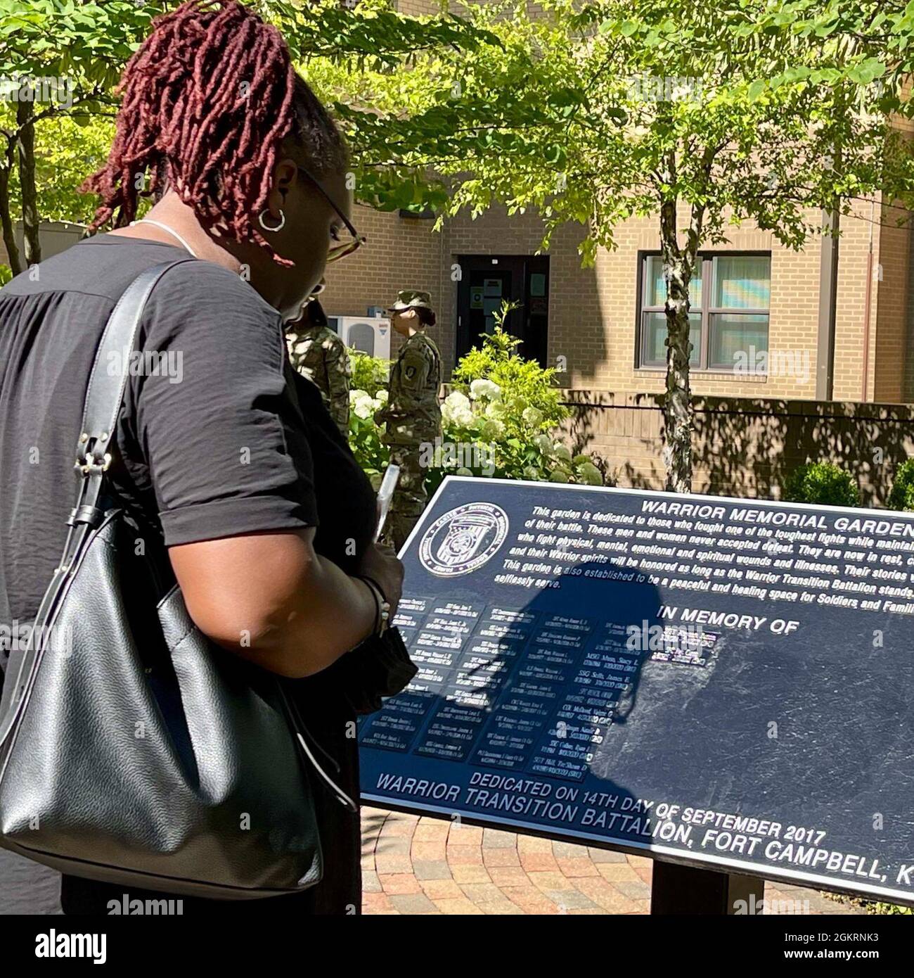 Ein Familienmitglied liest die Namen von Soldaten, die im Fort Campbell Soldier Recovery Unit Warrior Memorial Garden geehrt werden. Für Soldaten, die gegen eine lebenslange oder unheilbare Krankheit kämpfen, liegt der Schwerpunkt der SRU auf der Verbesserung der Lebensqualität des Soldaten, der Linderung körperlichen, emotionalen und spirituellen Leidens und der Unterstützung ihrer Angehörigen in einer sehr schwierigen Zeit. Stockfoto
