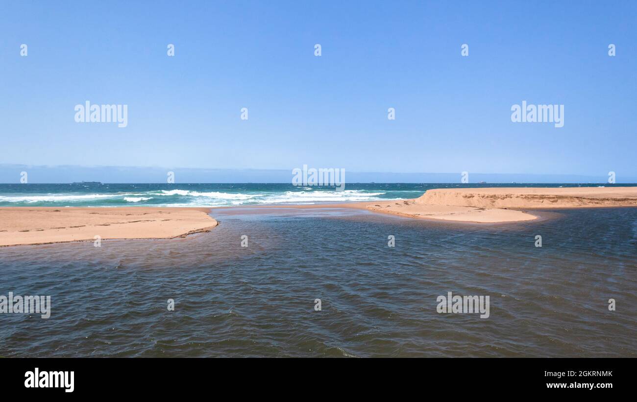 Strand-Sandbänke mit Flussmündung Lagunenwasser fließt in Richtung der Ozeanwellen blauen Horizont. Stockfoto