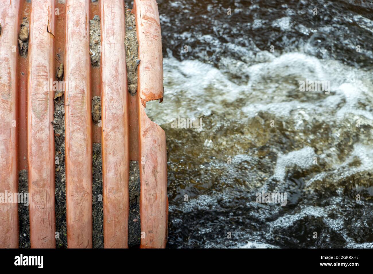 Aus einem großen flexiblen Rohr - Schlauch fließt ein Wasserstrom. Stockfoto