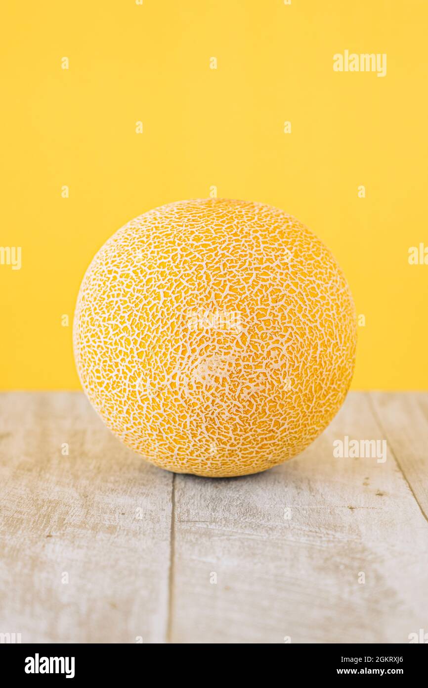Gelbe Galia Melone auf Holztisch und gelber Hintergrund Stockfoto