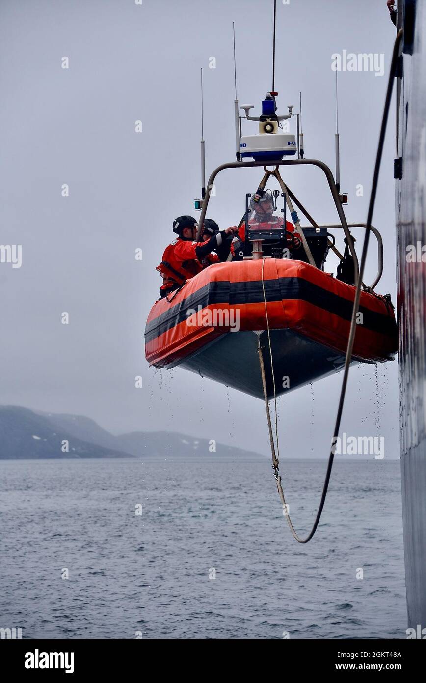 Die Besatzung des USCGC Maple (WLB 207) nimmt an einer Such-, Rettungs- und Verschmutzungsreaktionsübung mit Mitgliedern des Atlantic Strike Teams der US-Küstenwache, des Incident Management Assist Teams, der HDMS Ejnar (P571), eines Patrouillenschiffs der Königlichen Dänischen Marine der Knud Rasmussen-Klasse, der FNS Fulmar (P740), Teil. Ein Patrouillenschiff der französischen Marine, die Sisak, ein Patrouillenschiff der grönländischen Marine, und die Feuerwehr Nuuk während eines simulierten Verschmutzungsvorfalls im Godthaab-Fjord, Grönland, 24. Juni 2021. Dies ist das erste Jahr, in dem das Joint Arctic Command die maritime Umweltreaktion in Argus eingliederte. Es war auch die Tanne Stockfoto