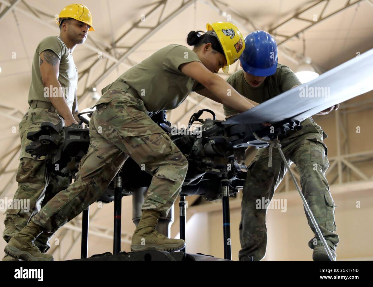Spc. Daniel Scott, links, SPC. Rose Curran und SPC. William Cordoza, alle Hubschrauber-Mechaniker der UH-60 Black Hawk und Bravo Company, 640. Aviation Support Bataillon, bereiten sich darauf vor, vor der Wartung eines Black Hawk im Camp Buehring, Kuwait, ein Hubschrauberblatt zu lösen. Stockfoto