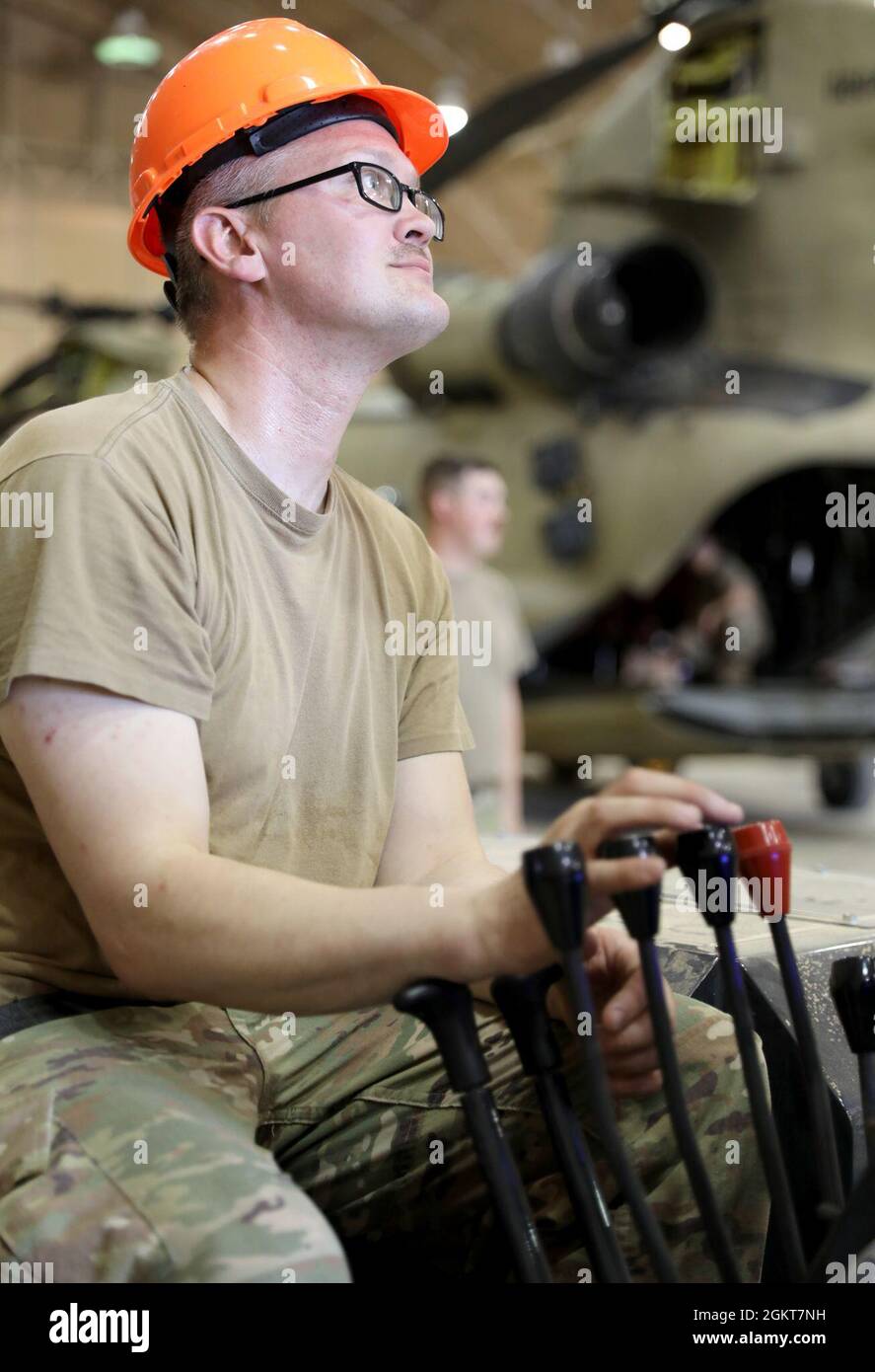 Personal Sgt. Daniel Adrian, ein Hubschrauber-Reparaturdienst der UH-60 Black Hawk mit Bravo Company, 640. Aviation Support Battalion, betreibt einen Spyder-Kran, um einen Hubschrauber der UH-60 Black Hawk für die Wartung im Camp Buehring, Kuwait, vorzubereiten. Stockfoto
