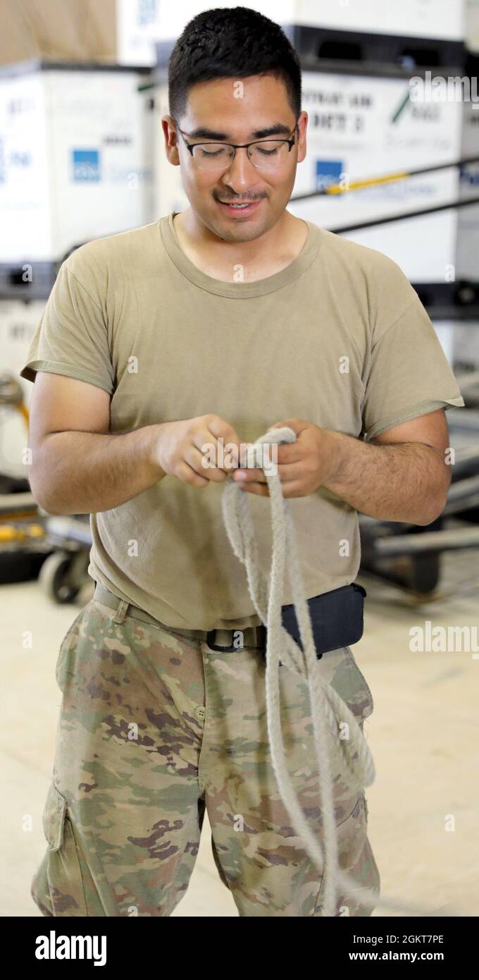 Spc. Daniel Nevarez, ein CH-47 Chinook Helikopter-Reparaturer mit Bravo Company, 640th Aviation Support Battalion, bindet ein Seil, mit dem die Rotorblätter eines CH-47 Chinook Hubschraubers im Camp Buehring, Kuwait, festgebunden werden. Stockfoto