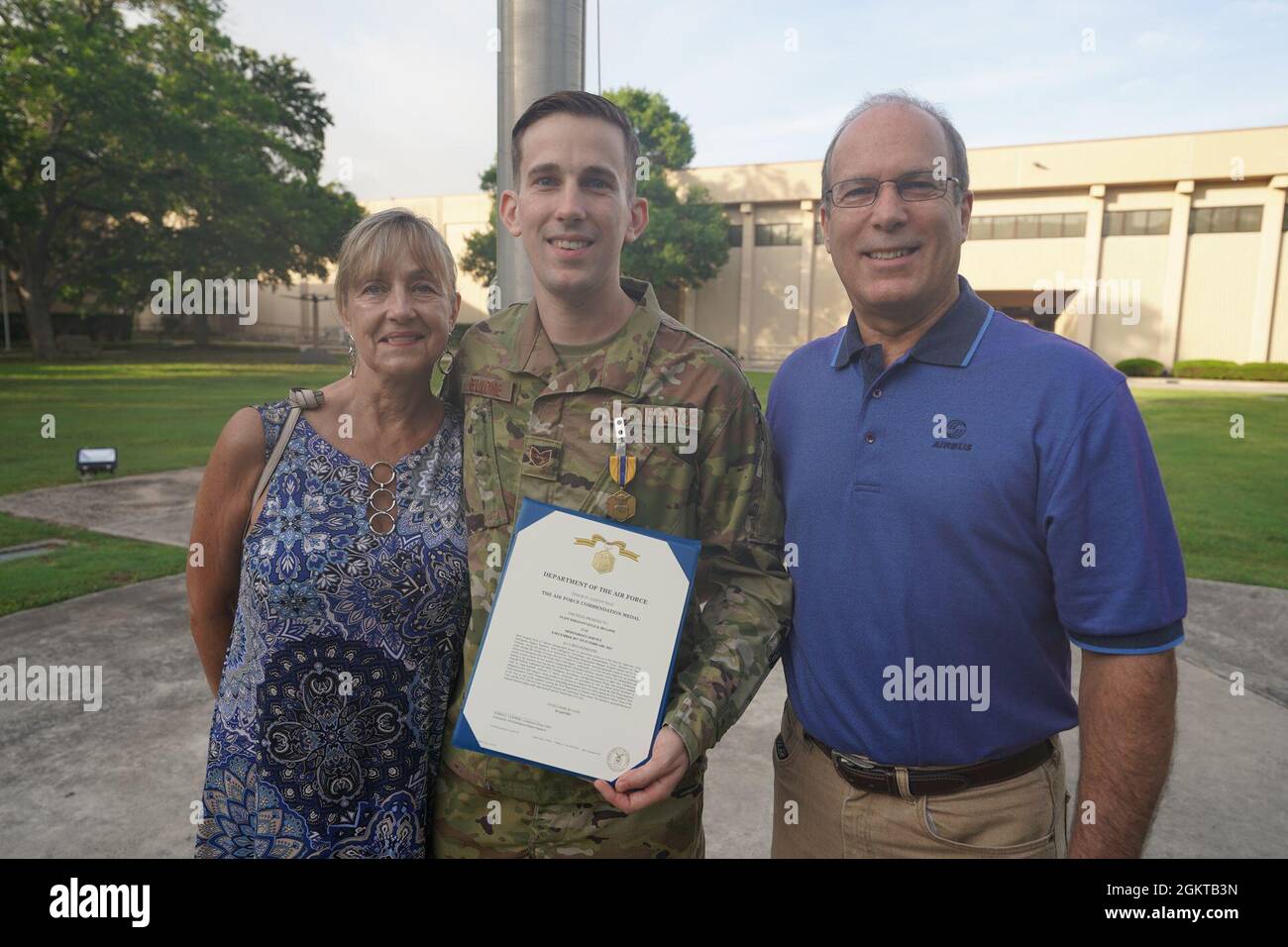 Tech Sgt. Kyle Bellone posiert mit seinen Eltern für ein Foto, nachdem er von Col. Steven Anderson, Kommandant des 688. Cyberspace Wings, im Juni 28, seine erste Auszeichnung für die Luftwaffe erhalten hatte. 2021, in der Joint Base San Antonio-Lackland, Texas. Stockfoto