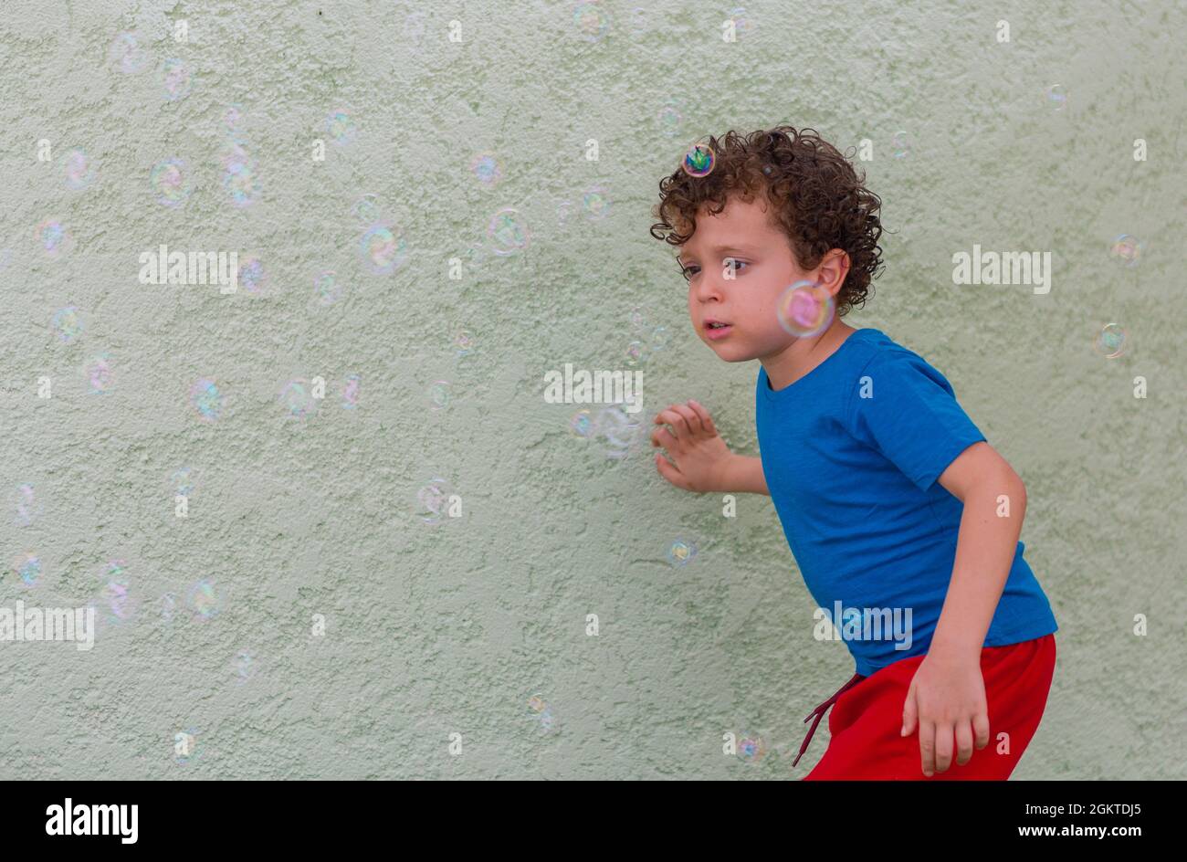 Kind spielt auf dem Spielplatz mit Seifenblasen Stockfoto