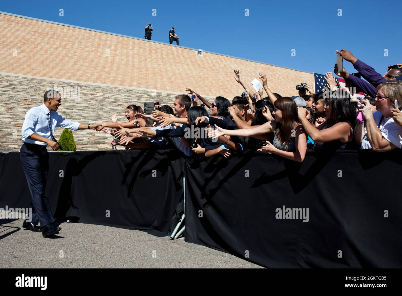 27. September 2011"der Präsident schüttelt die Hände mit den Studenten, bevor er Bemerkungen zum American Jobs Act an der Abraham Lincoln High School in Denver abgibt. Die breitere Ansicht zeigt auch das Sicherheitspersonal auf dem Dach.“ (Offizielles Foto des Weißen Hauses von Pete Souza) Dieses offizielle Foto des Weißen Hauses wird nur zur Veröffentlichung durch Nachrichtenorganisationen und/oder zum persönlichen Druck durch die Betreffzeile(en) des Fotos zur Verfügung gestellt. Das Foto darf in keiner Weise manipuliert werden und darf nicht in kommerziellen oder politischen Materialien, Werbung, E-Mails, Produkten oder Werbeaktionen verwendet werden, die in irgendeiner Weise sug Stockfoto